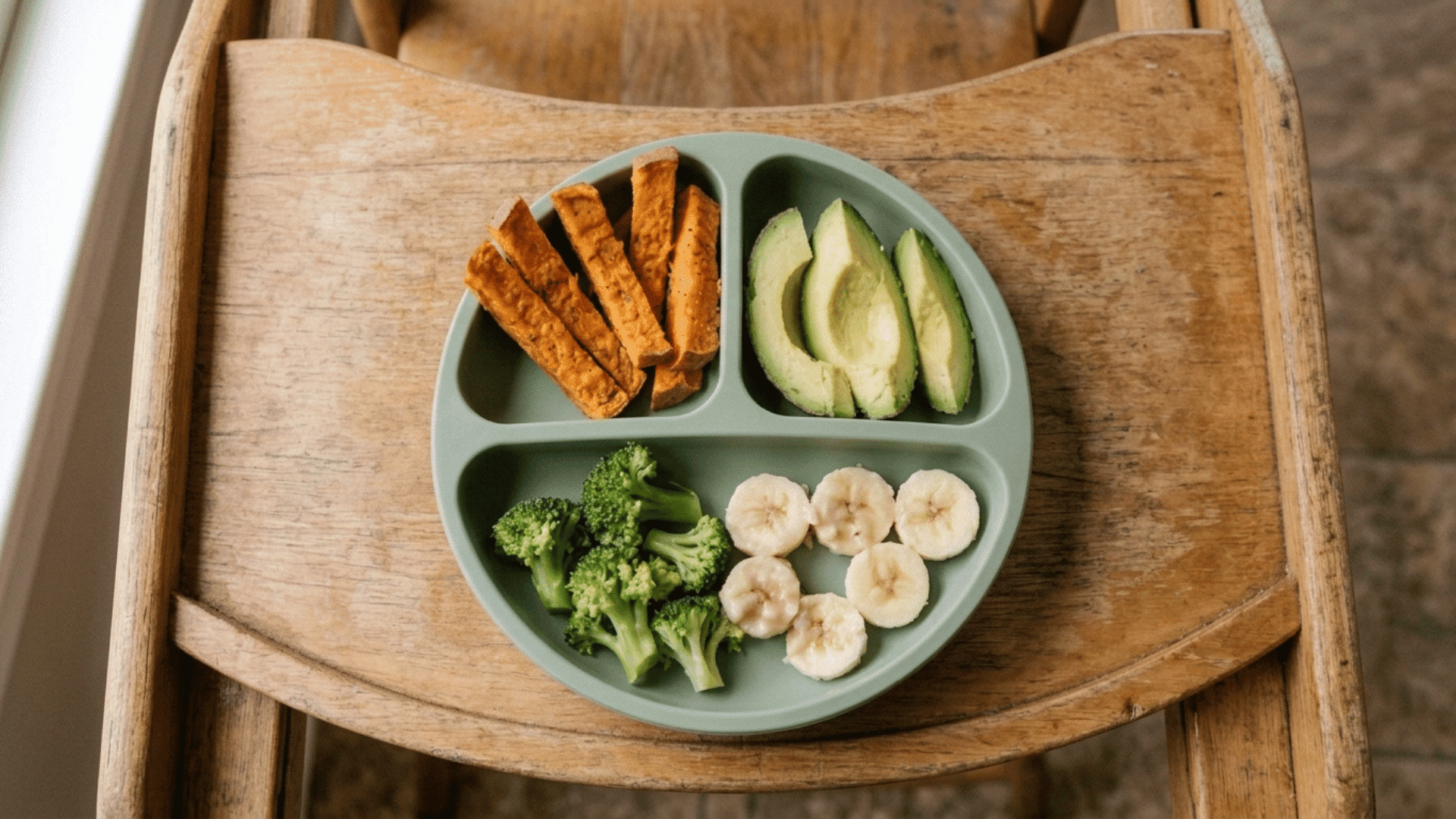 divided plate with sweet potato fries, avocado, broccoli, and banana for baby led weaning recipes
