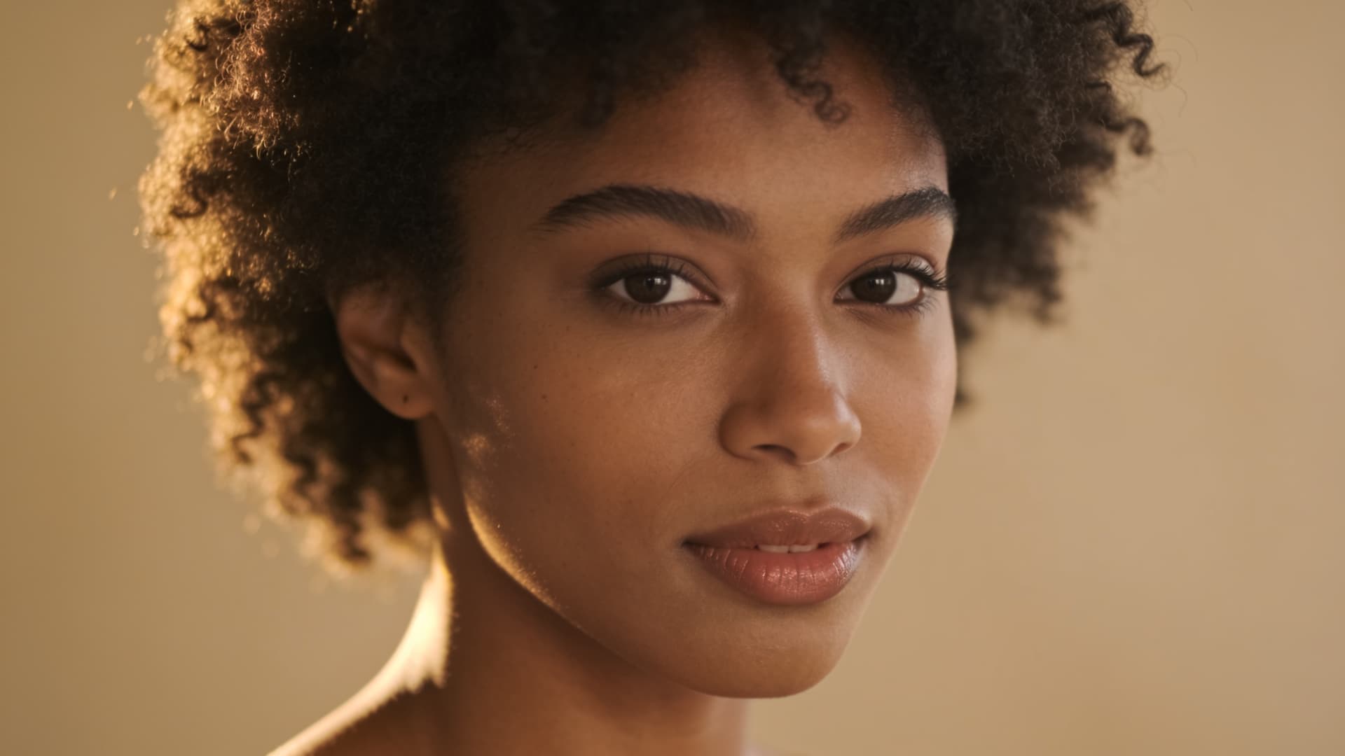 black woman with a rounded afro featuring dense healthy coils and a balanced even silhouette