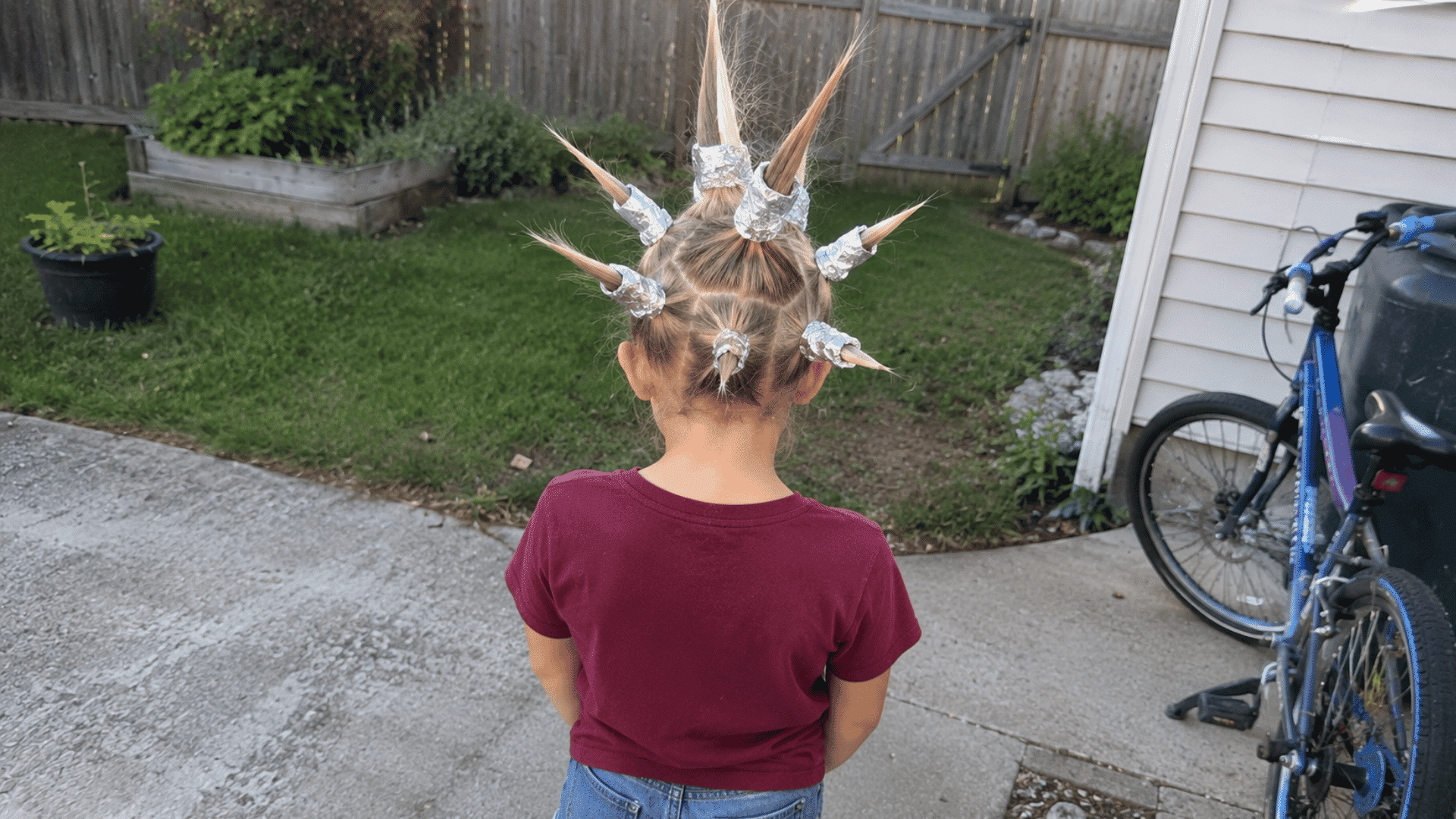 blonde hair styled into spikes wrapped in foil in backyard driveway