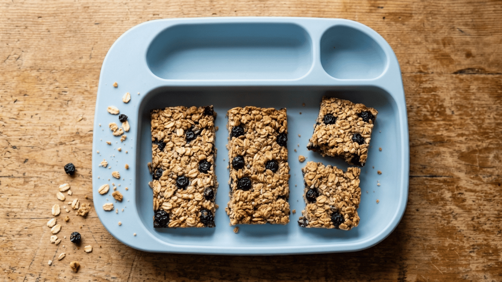 blueberry oat bars broken in half on a toddler tray as an easy baby led weaning snack