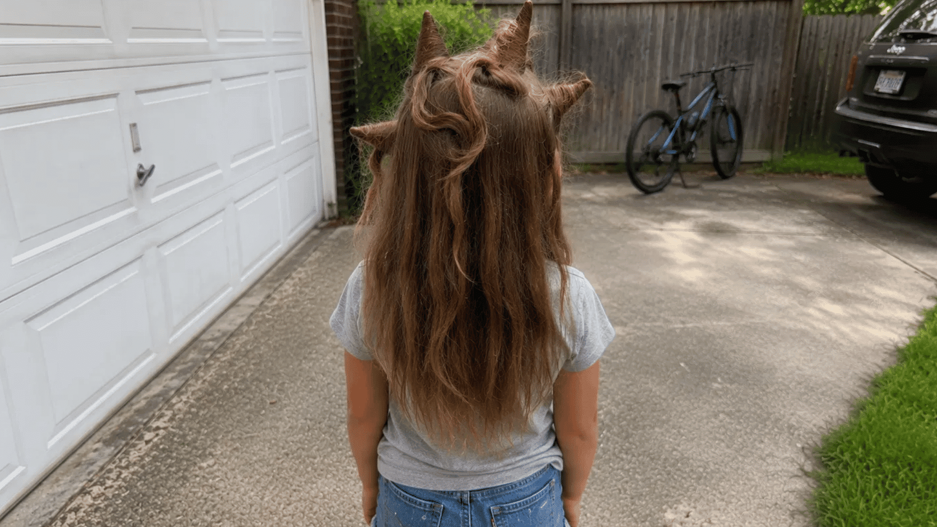 brown hair sculpted into pointed spikes over hidden foil in driveway
