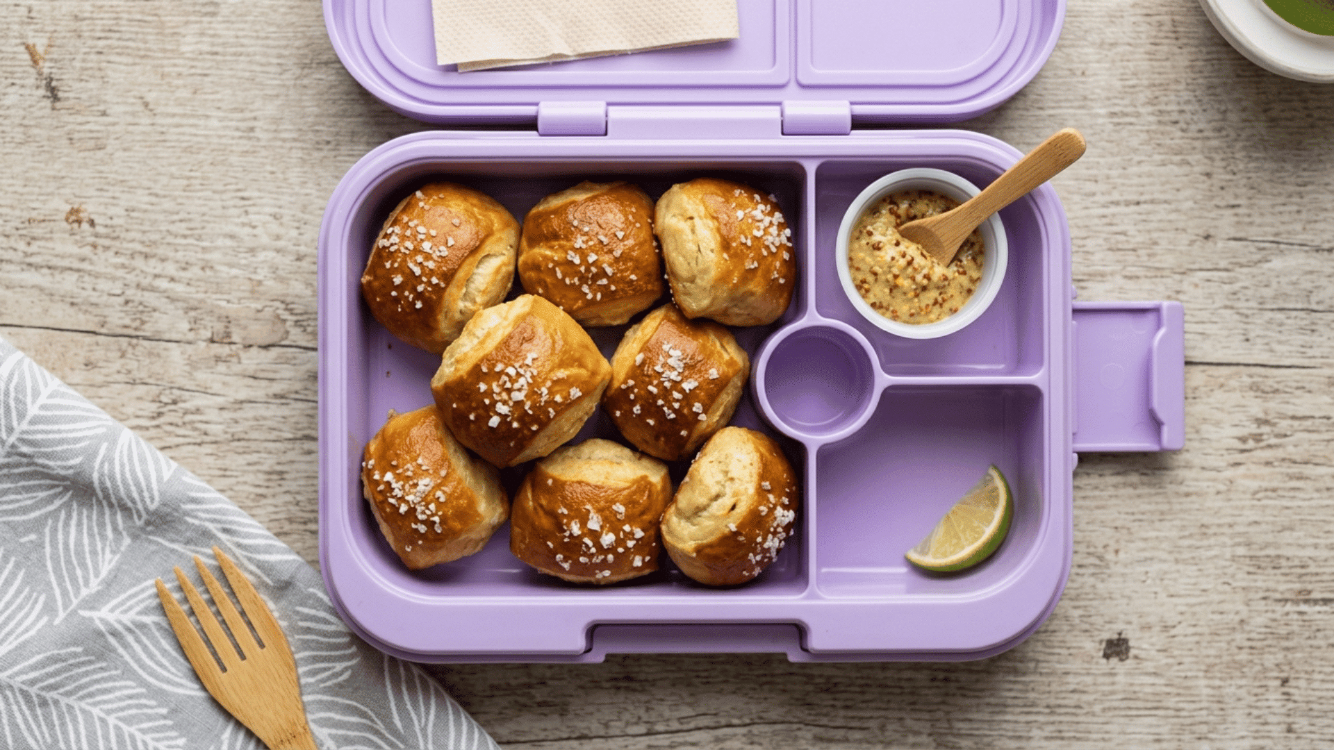 soft pretzel bites with mustard dip packed in a purple plastic lunchbox