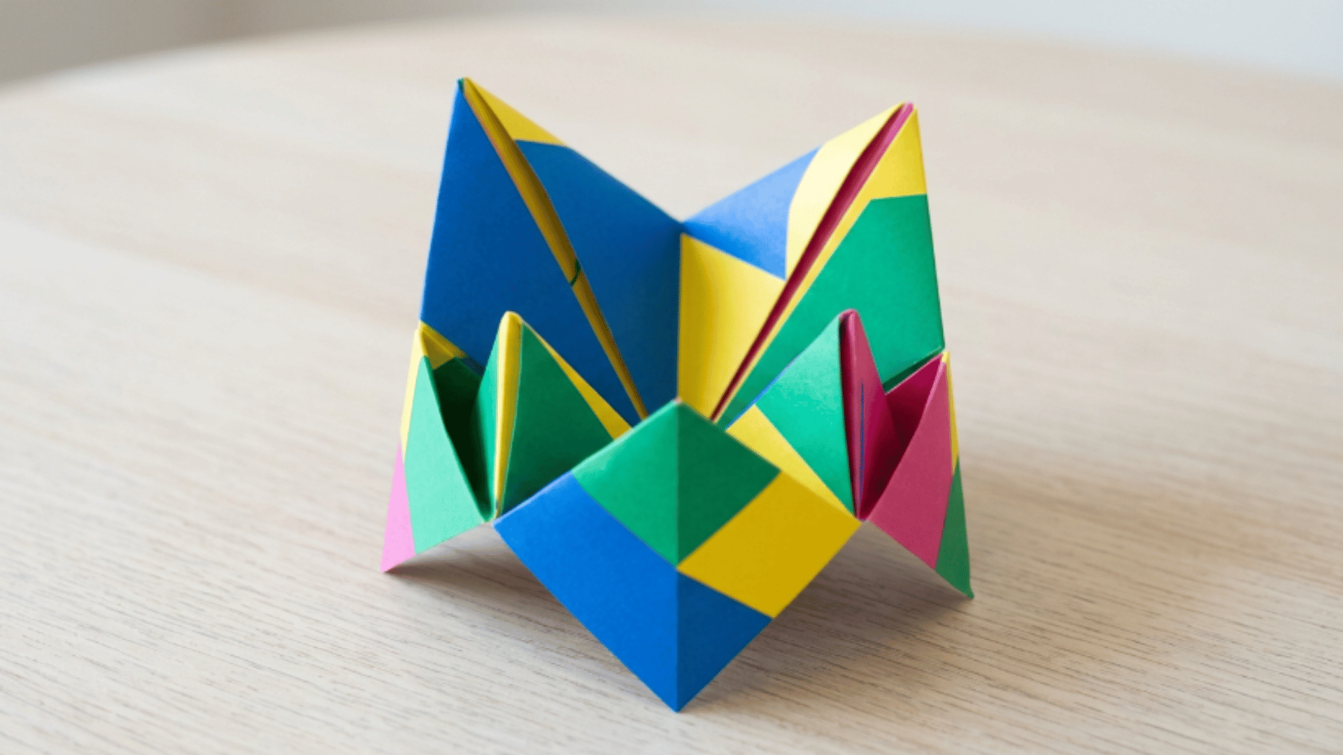 colorful origami fortune teller placed open on a flat surface showing neat folds and bright paper