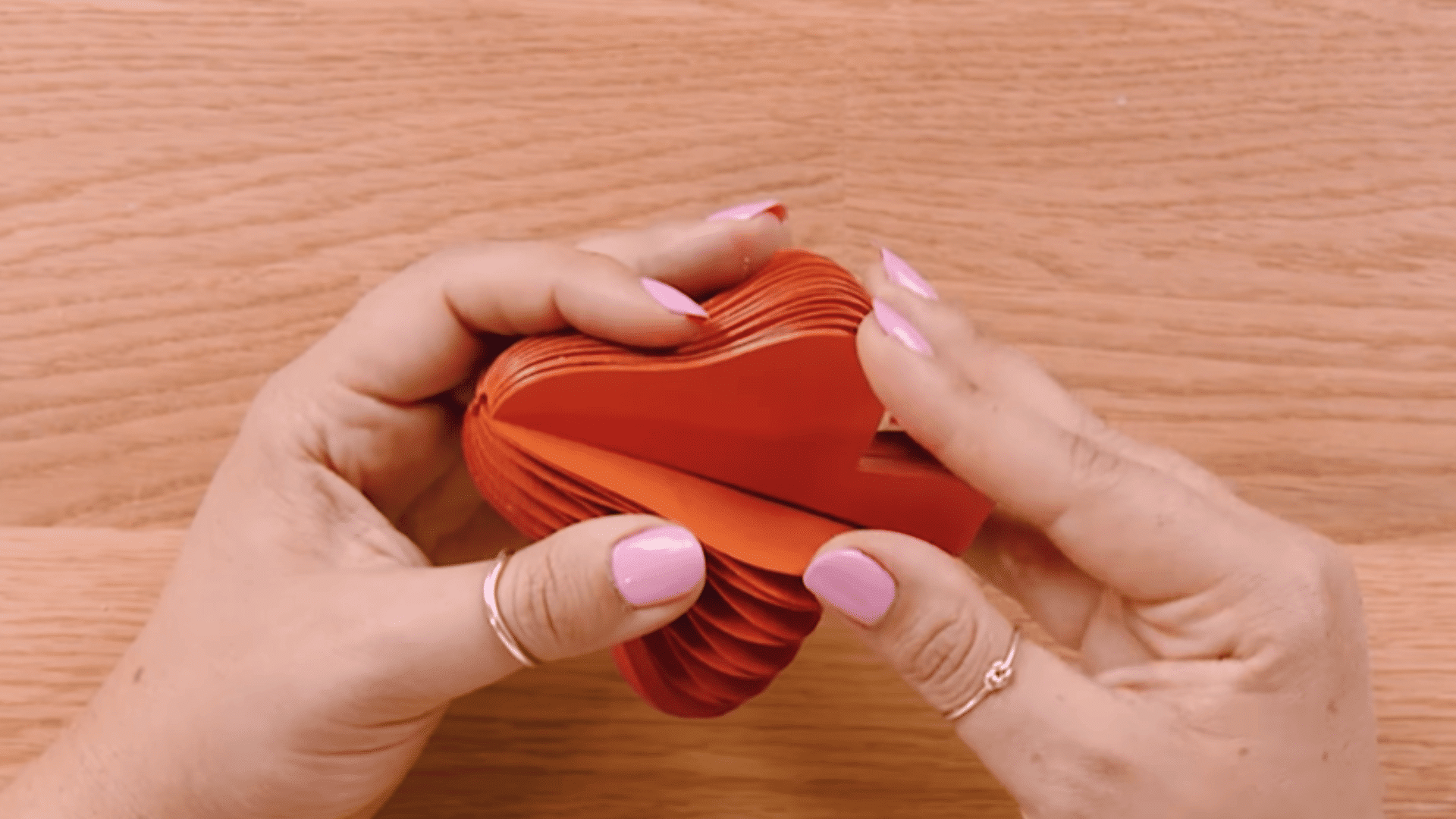 gently opening layered cardstock pieces to form a honeycomb pattern and separating stuck layers