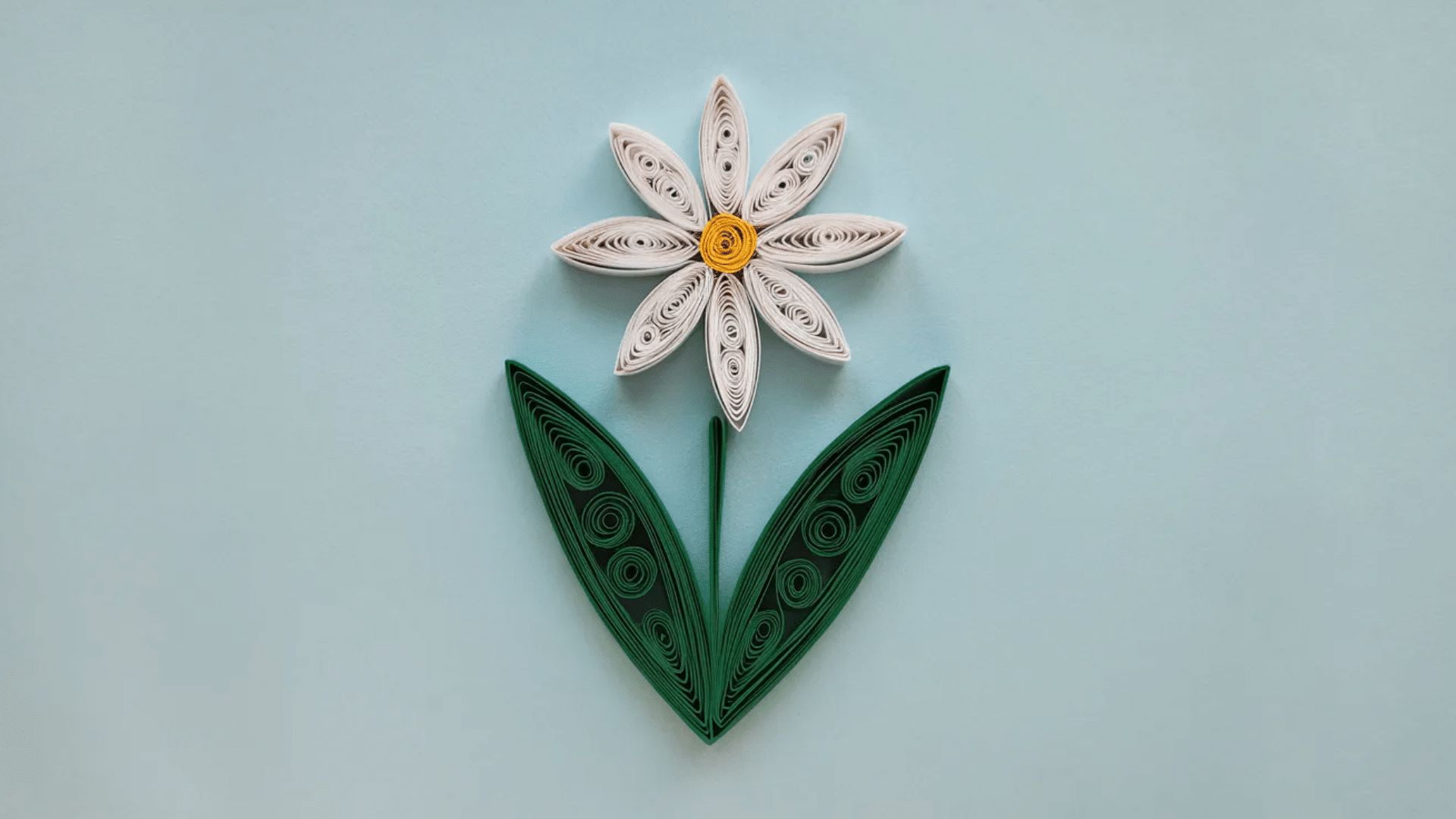 intricate paper quilling design featuring tightly rolled and shaped colorful paper strips arranged into a flower pattern