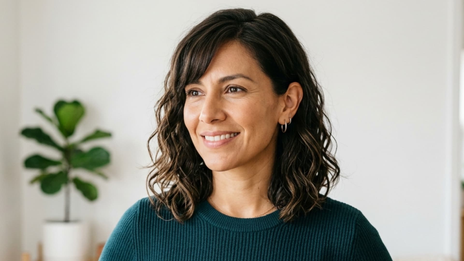 latina woman with a collarbone cut and chin length fringe tucked softly behind one ear
