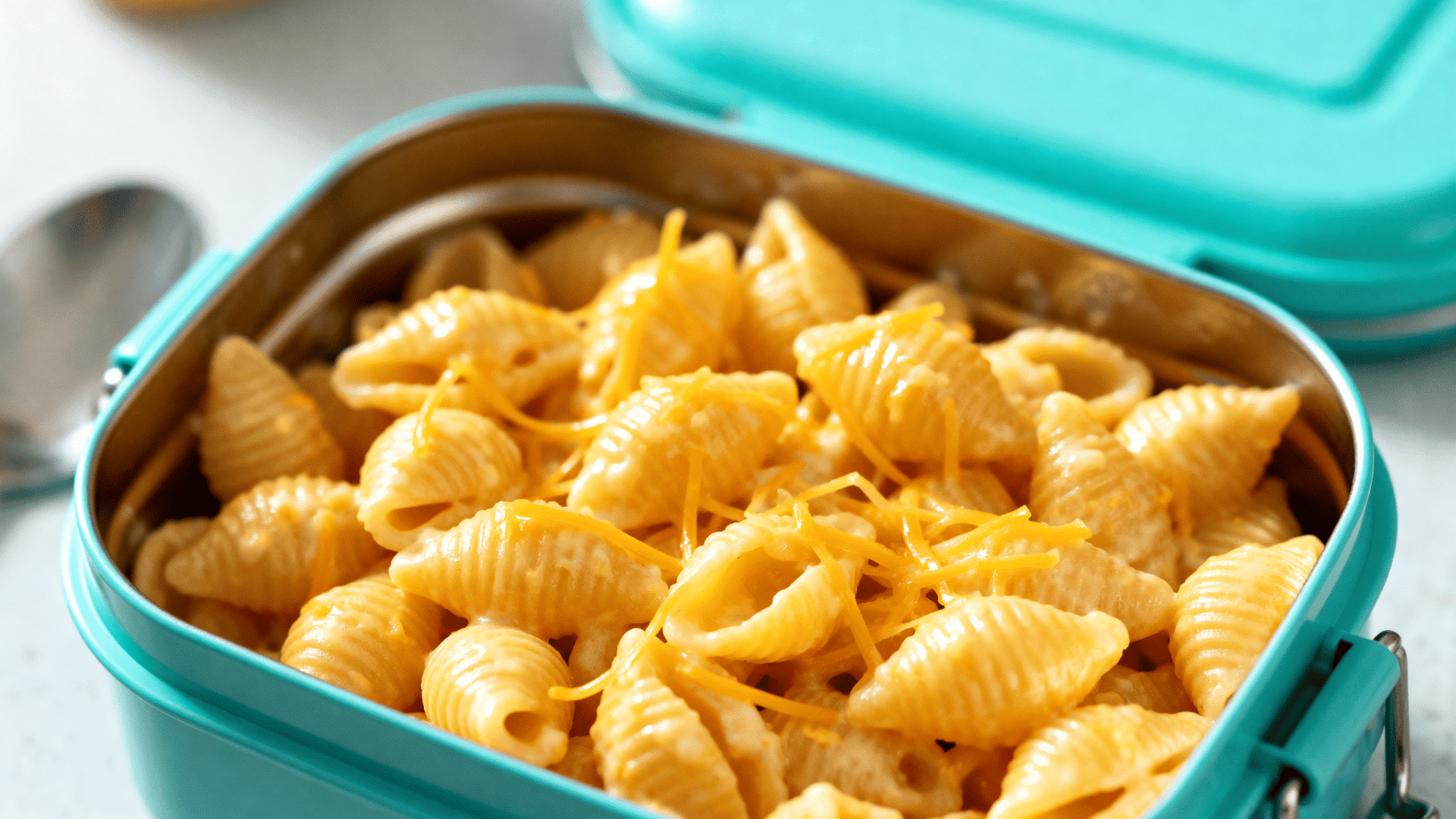 creamy cold mac and cheese in a teal stainless steel lunchbox