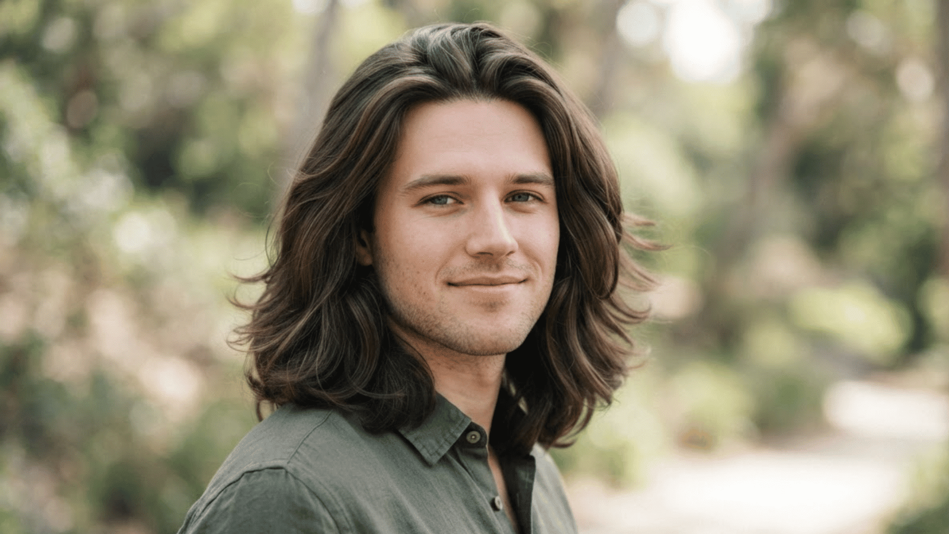 man with long flow haircut outdoors showing layered hair and natural volume