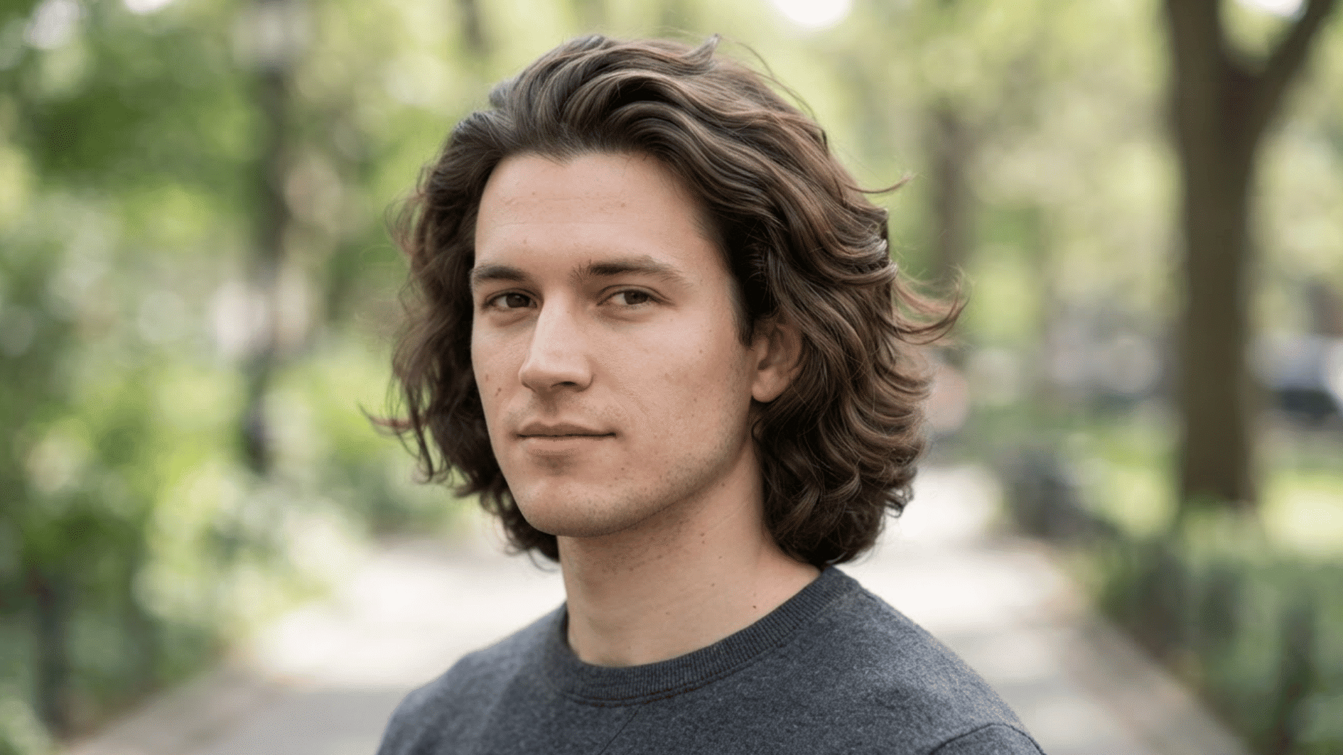 man with long flow haircut outdoors showing wavy layered hair and natural texture