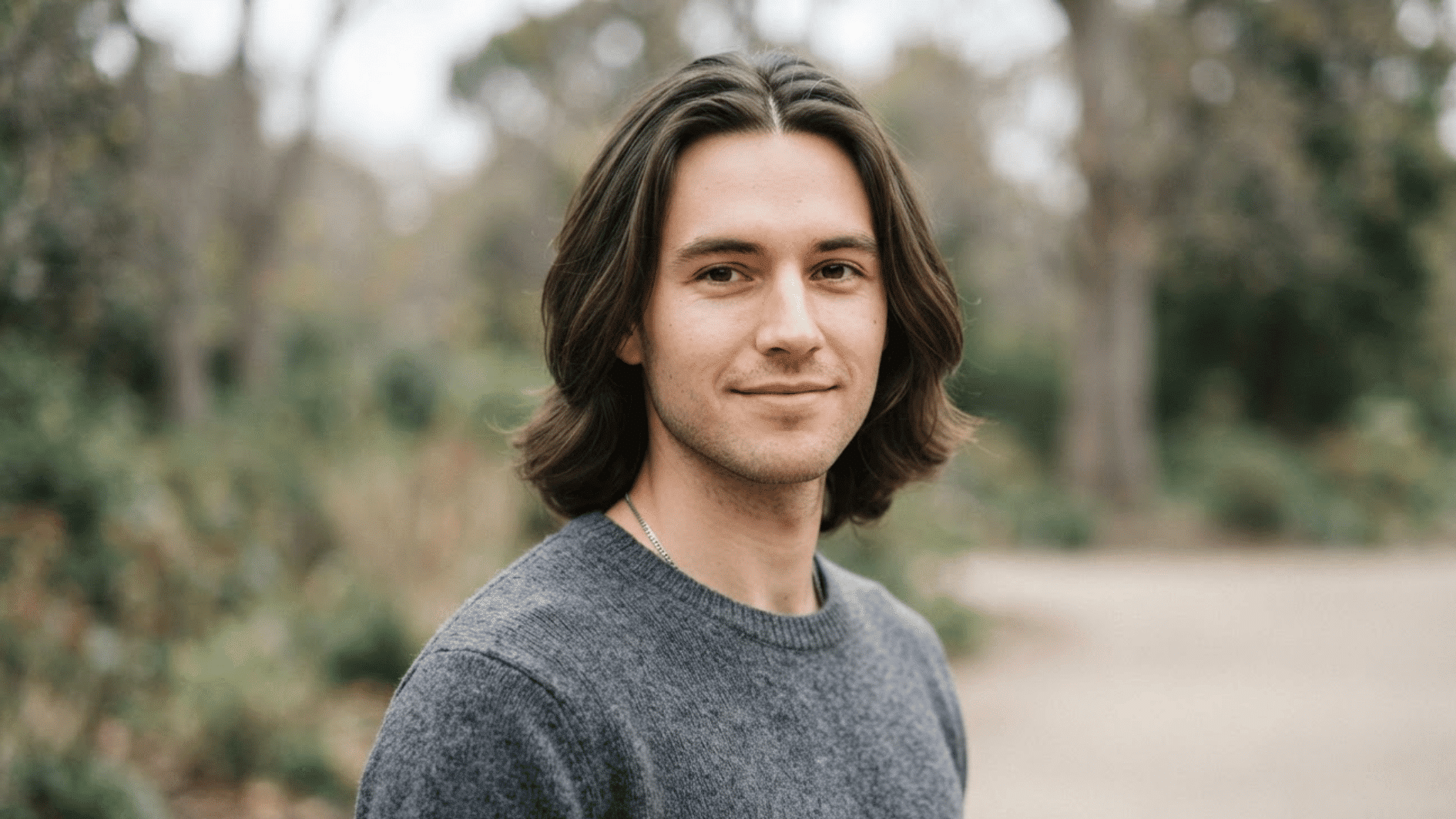 man with long layered flow haircut outdoors showing smooth hair and natural movement