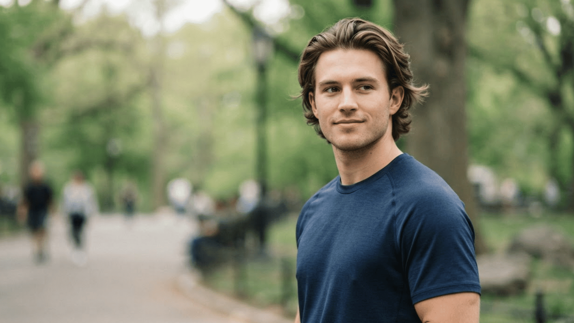 man with medium length flow haircut outdoors showing natural layers and relaxed swept back hair style