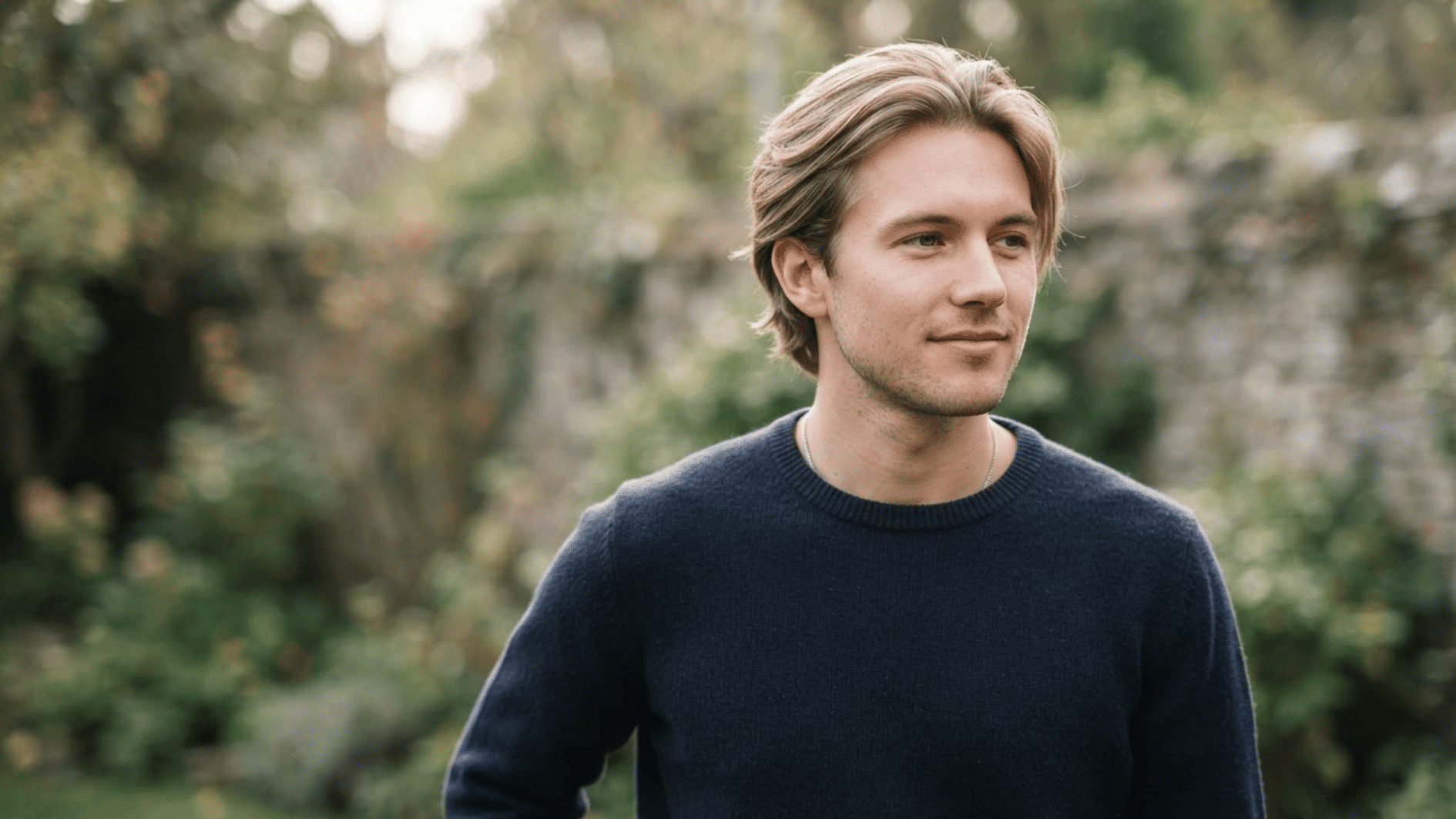 man with straight flow haircut outdoors showing smooth layered hair and natural swept back style
