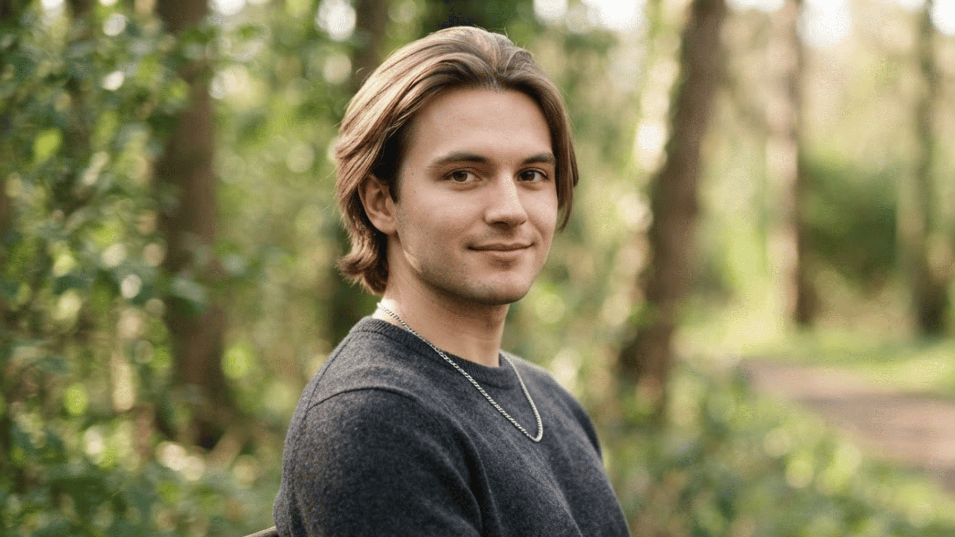 man with straight medium length flow haircut outdoors with natural hair movement and casual style
