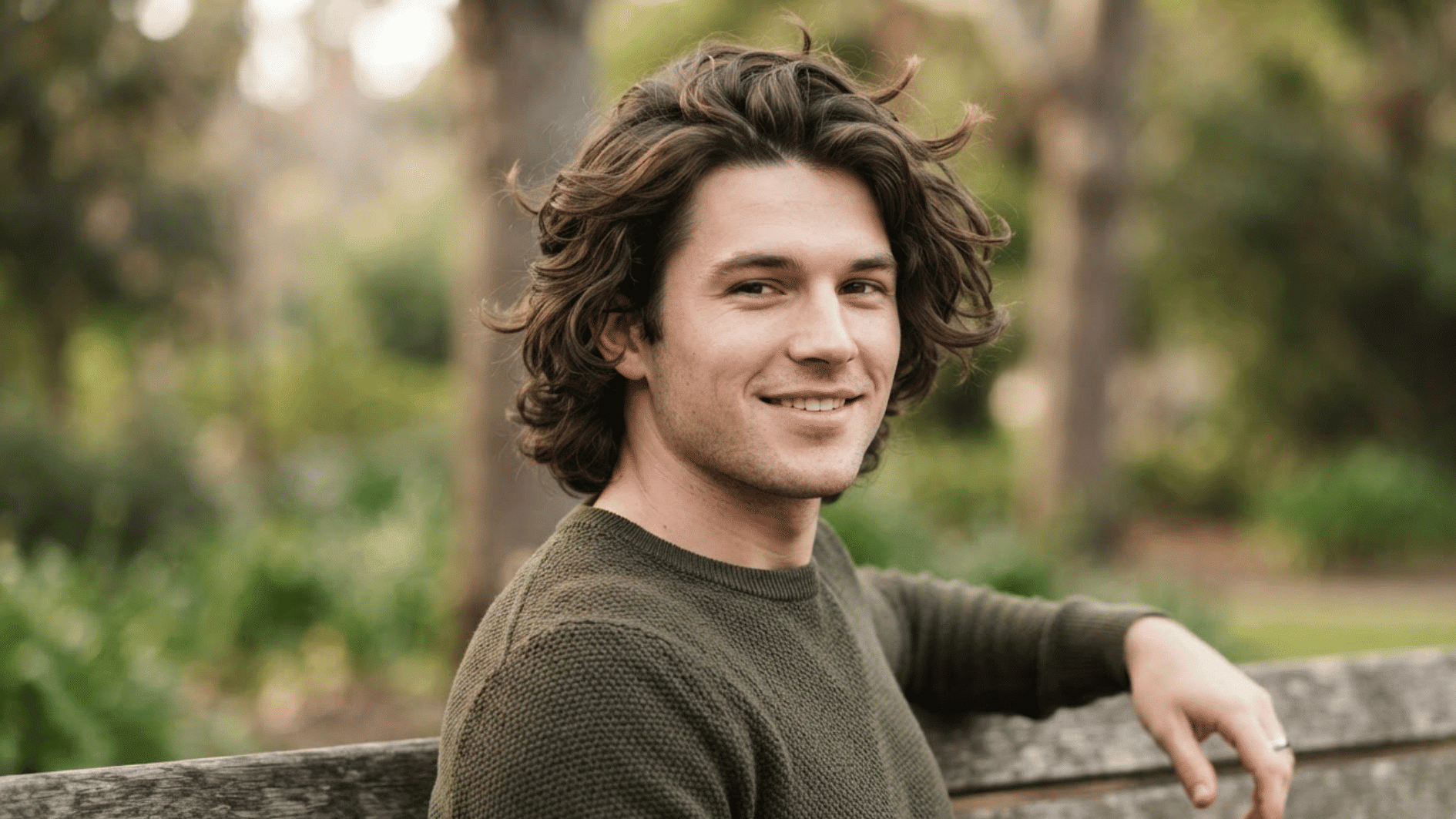 man with textured flow haircut outdoors showing natural volume and wavy layered hair style
