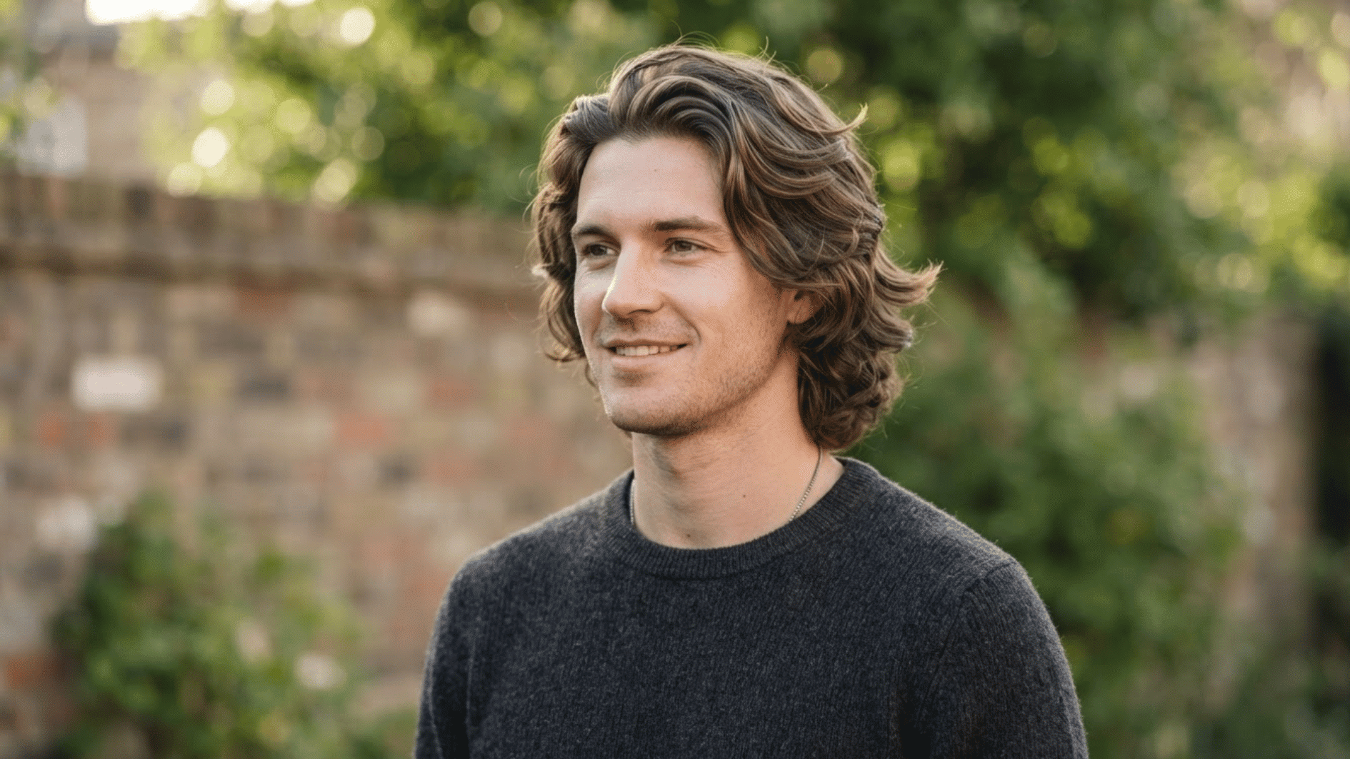 man with wavy flow haircut outdoors showing layered texture and natural hair movement