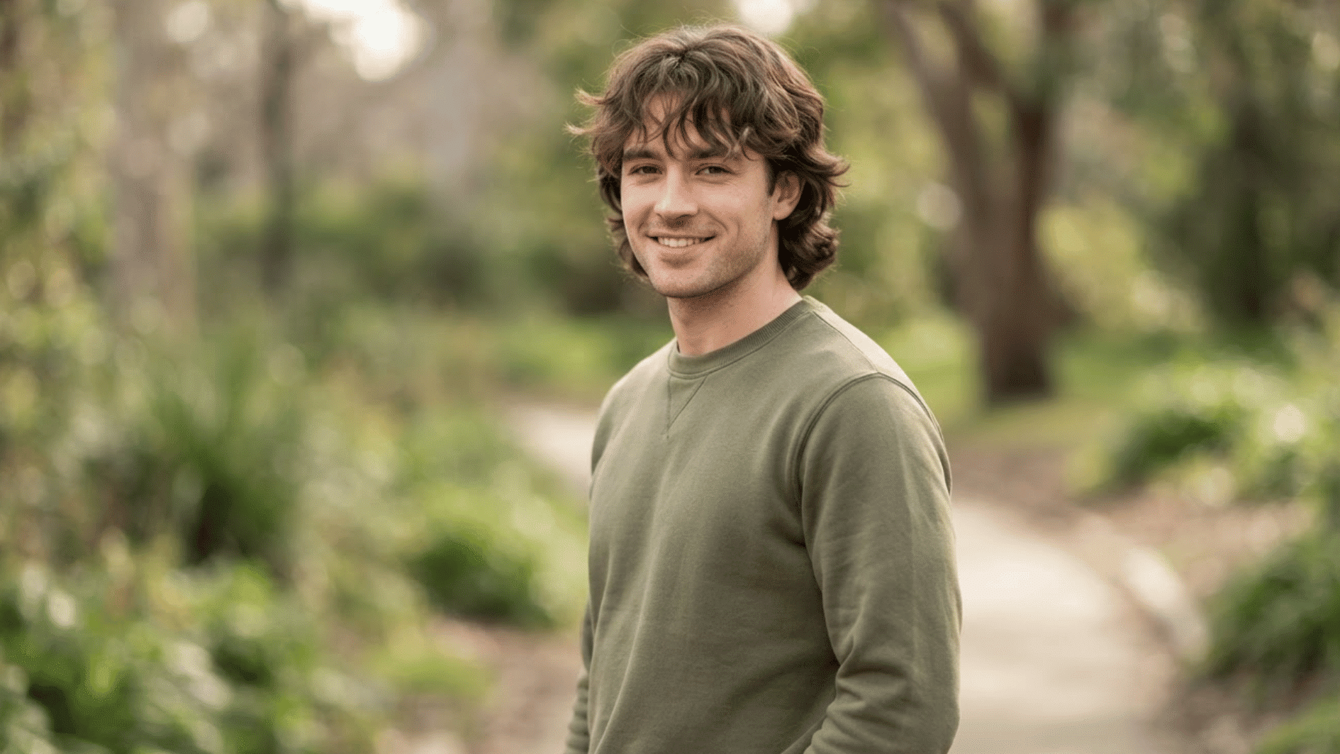 man with wavy flow haircut outdoors showing textured layers and natural hair movement