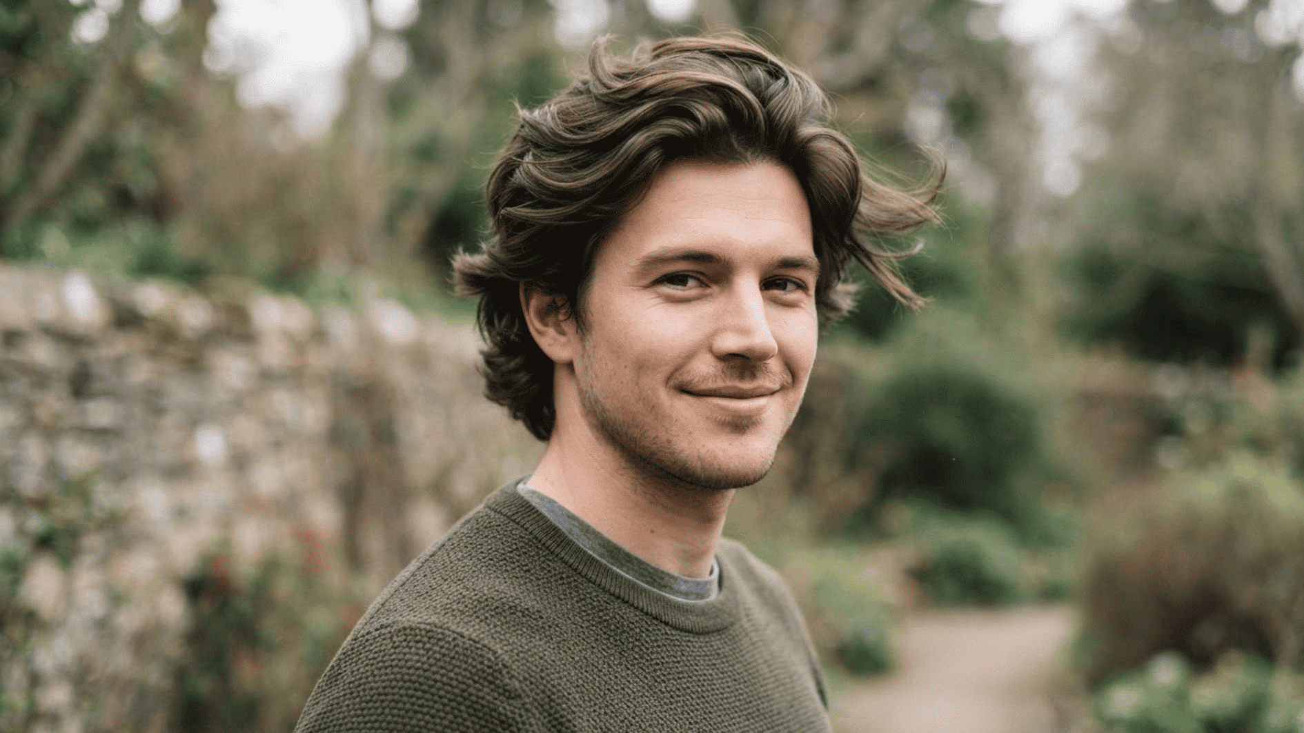 man with wavy flow haircut outdoors showing voluminous layered hair and natural texture
