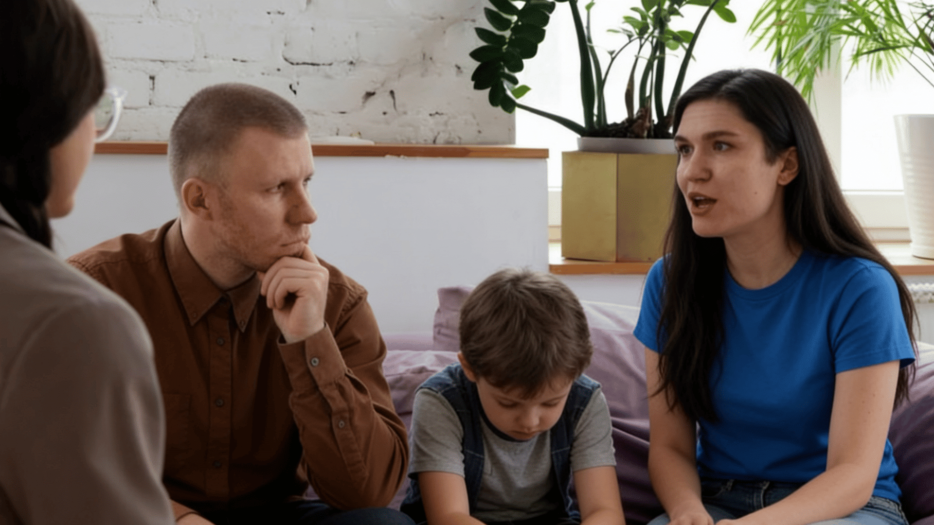 parents and child meet a mental health professional for family counseling in a calm safe indoor setting