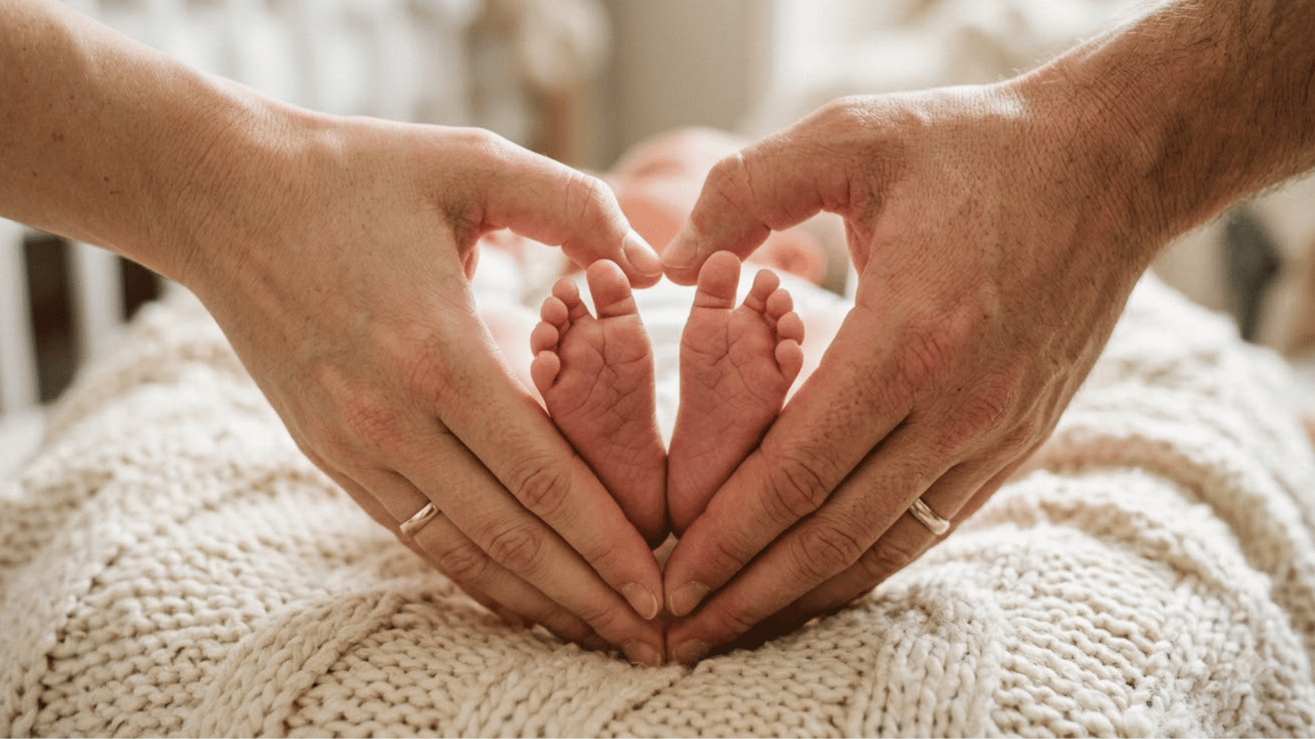 parents forming heart around the feet of little newborn baby