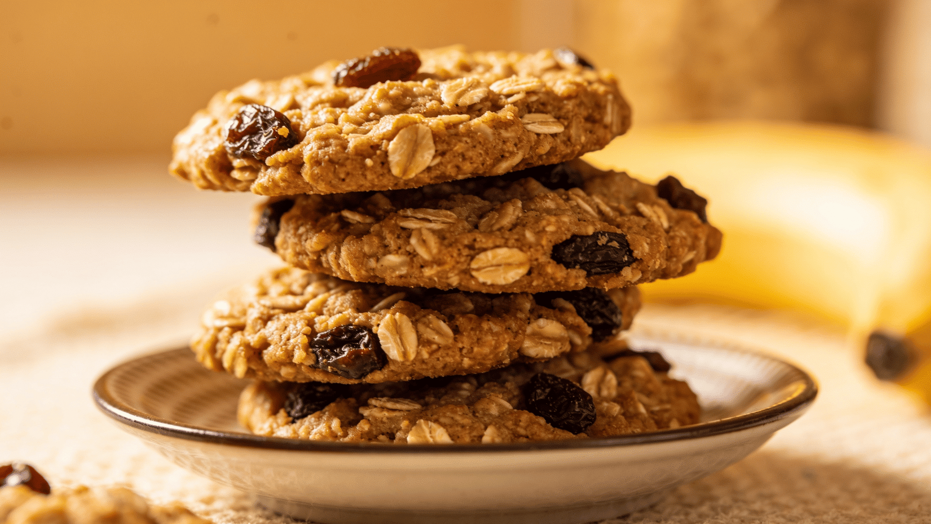rustic banana-oat cookies with raisins stacked on a small plate