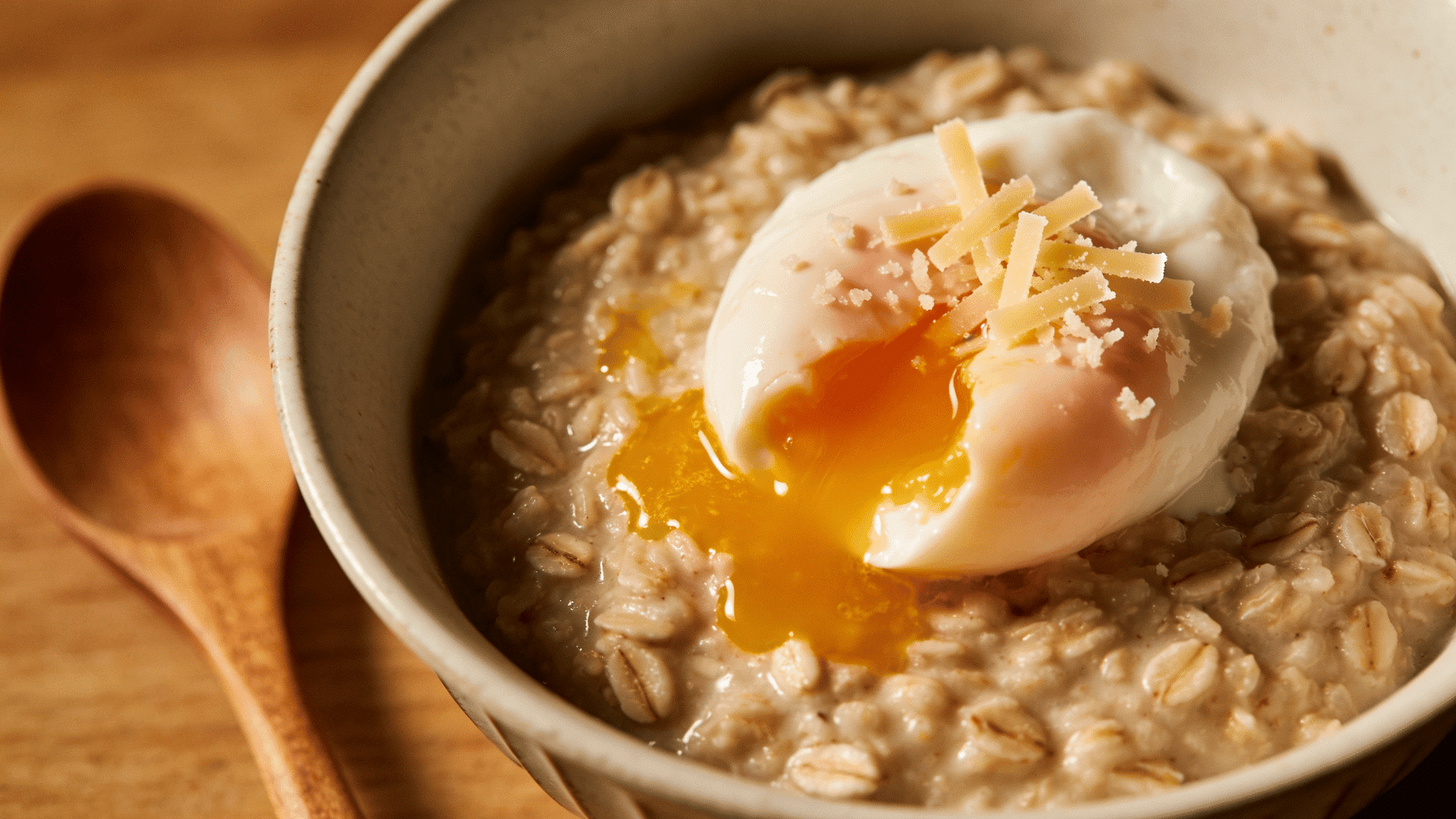 savory oatmeal bowl topped with a soft egg and a little grated cheese