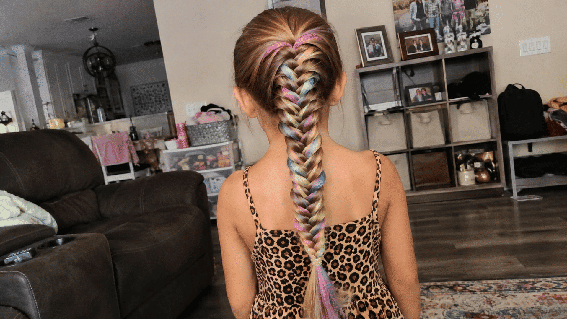 school girl with rainbow braided ponytail wearing leopard print dress in living room, real candid phone photo