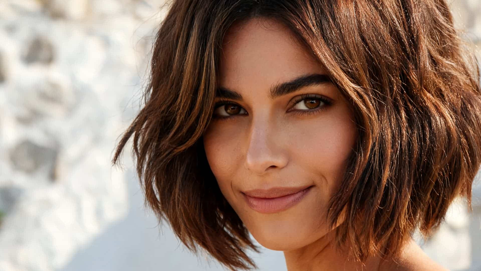 short layered haircut with face framing pieces and soft shaping around thick hair