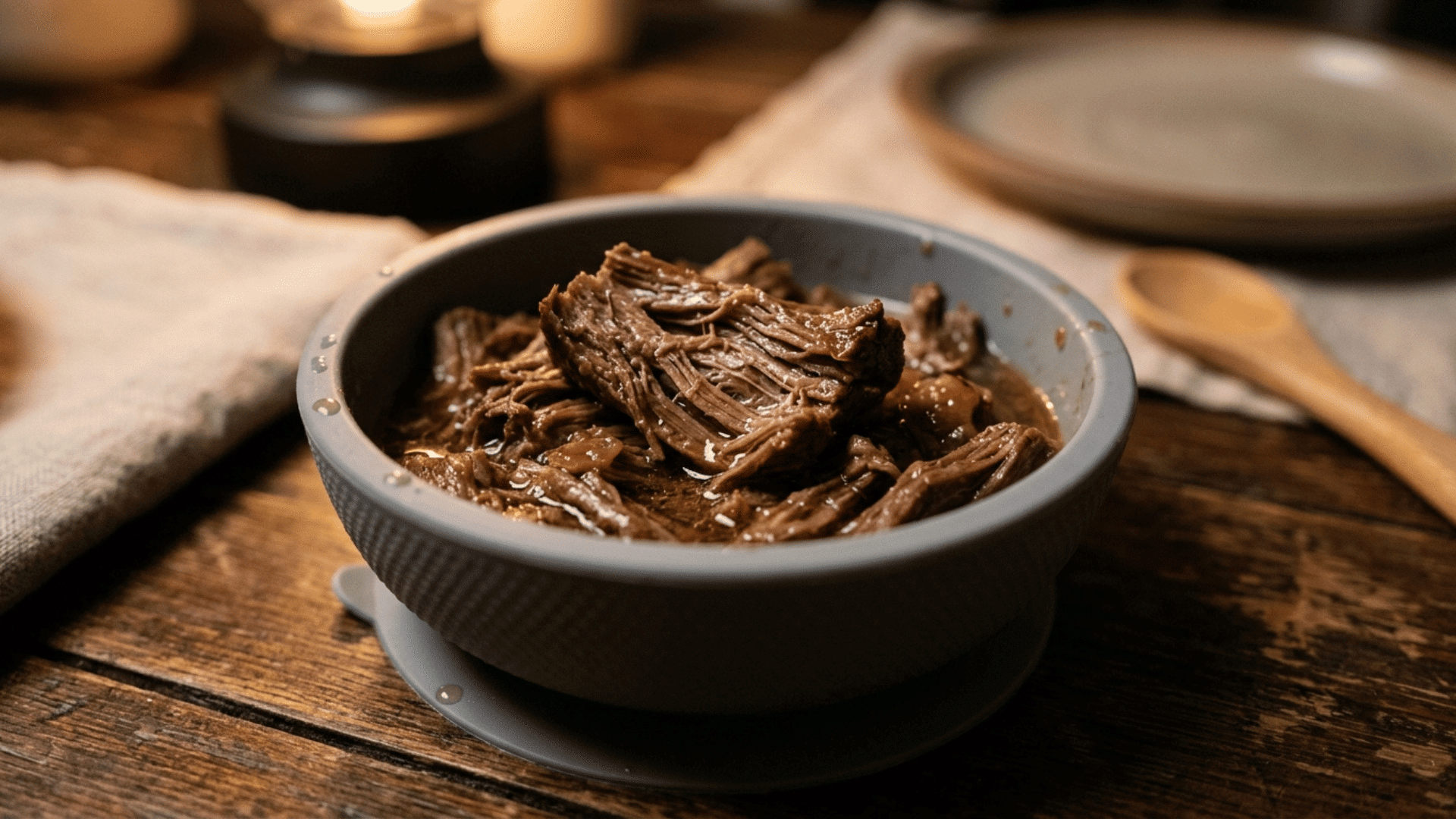 slow-cooked shredded beef strips in a gray suction bowl as an iron-rich baby dinner