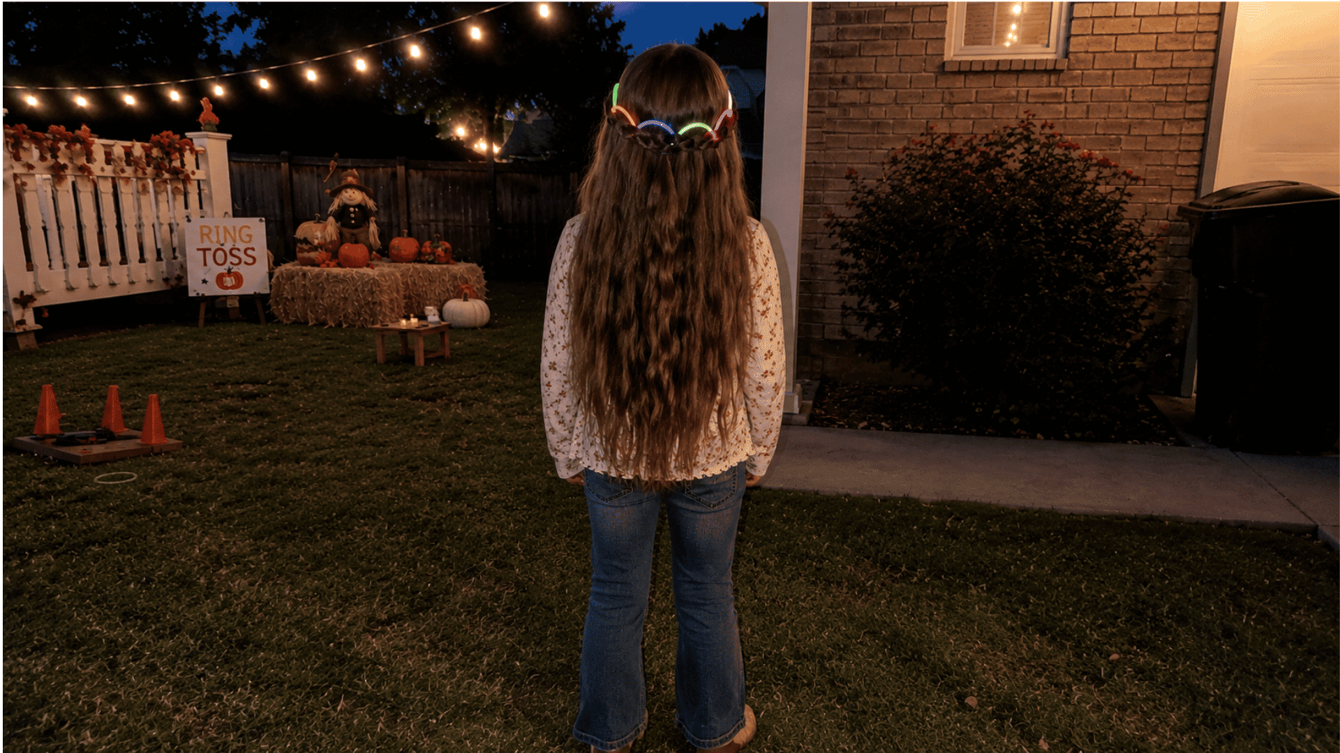 small girl with glowing pink green and blue glow sticks woven at crown