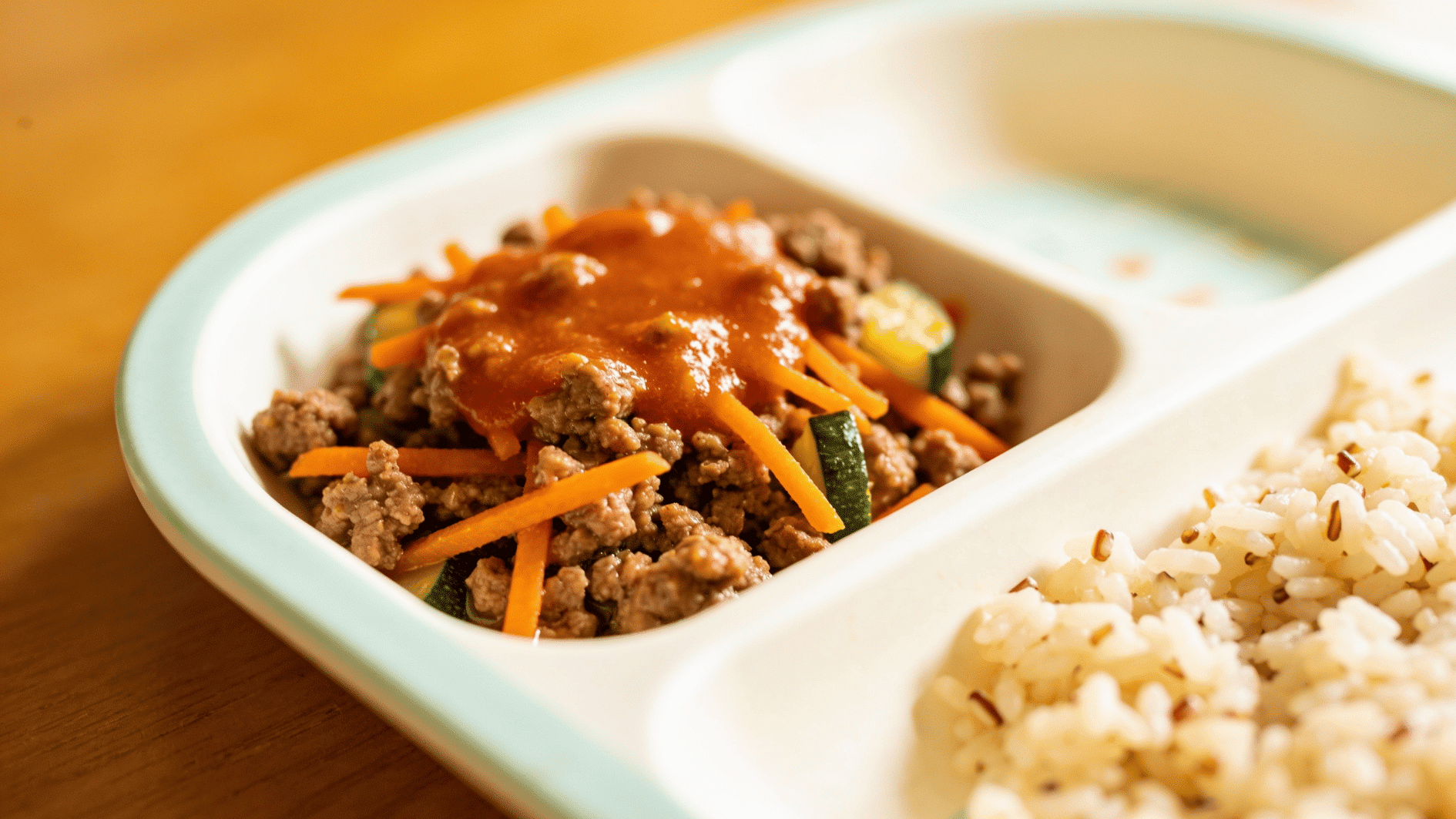 soft beef and vegetable mince served with rice in a divided toddler meal plate
