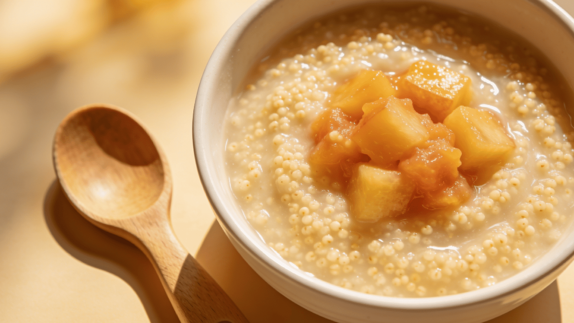 soft creamy bowl of millet porridge topped with mashed fruit