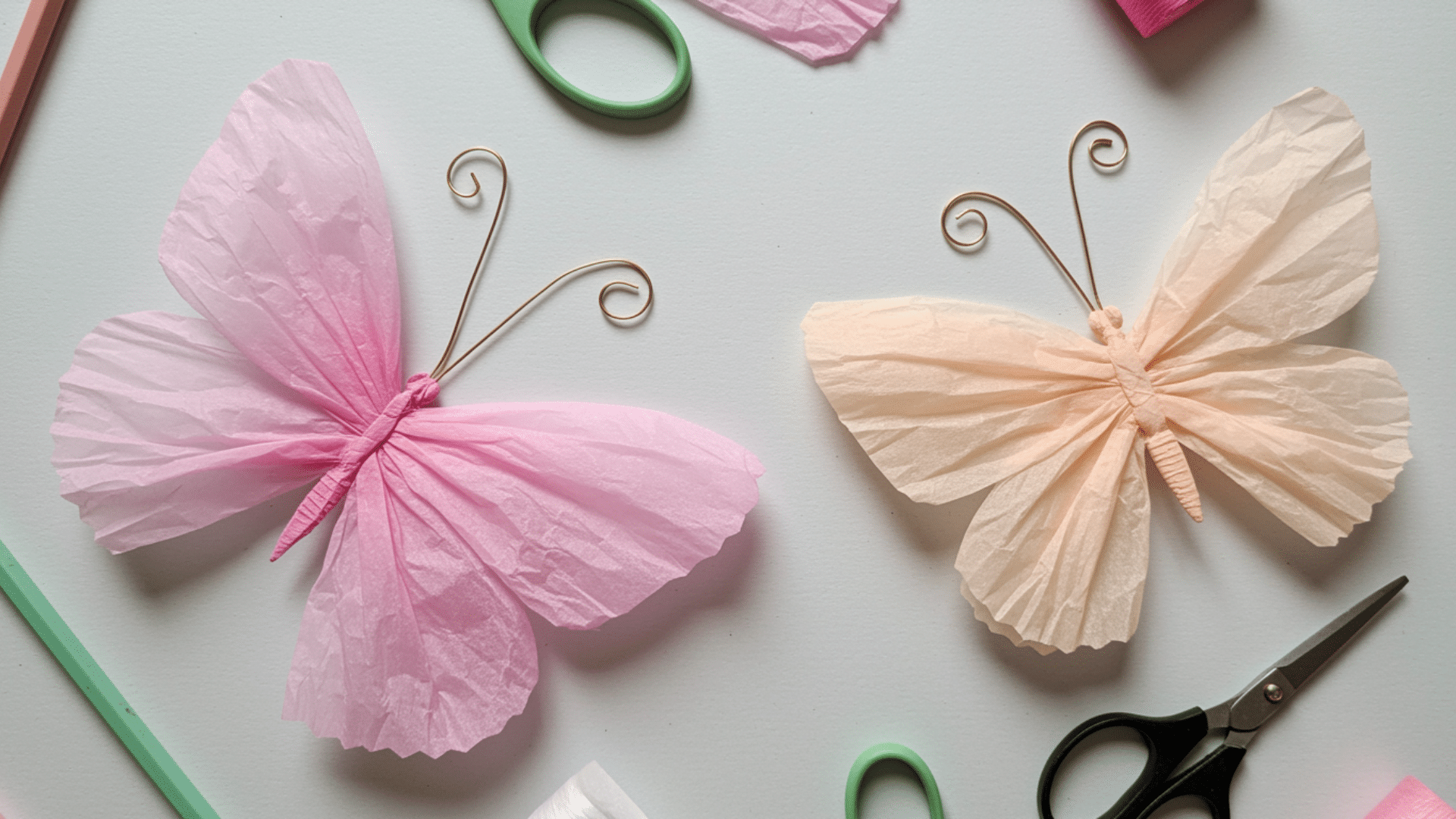 soft tissue paper butterflies with layered wings and pipe cleaner antennae in vibrant colors