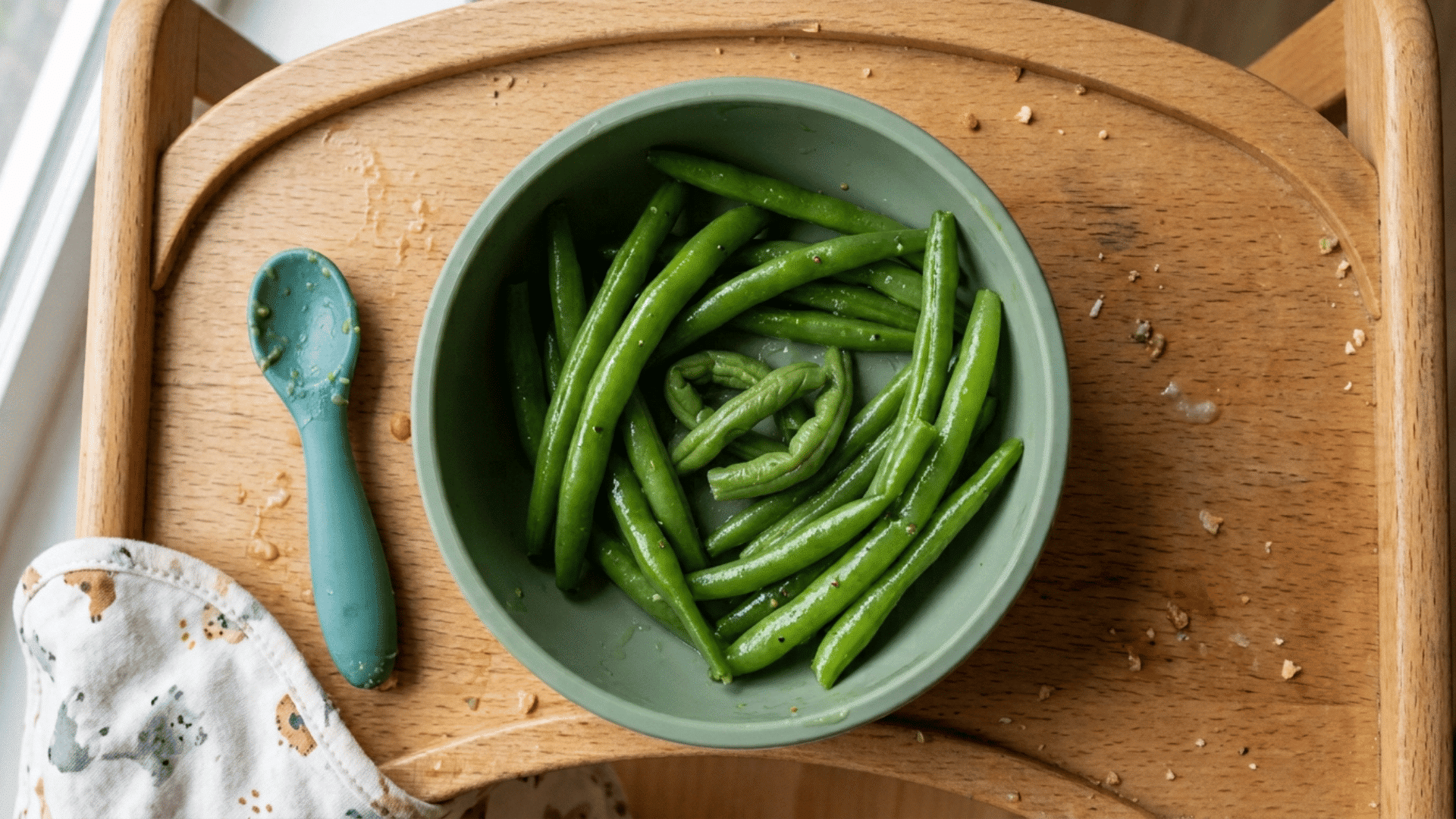 whole steamed green beans served in a suction bowl for baby led weaning finger food