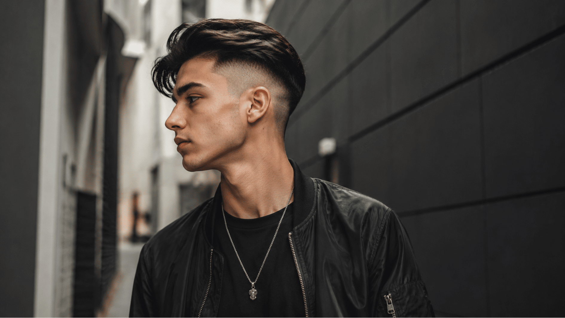 teen boy with drop fade haircut featuring curved faded sides and textured curls inside a school cafeteria