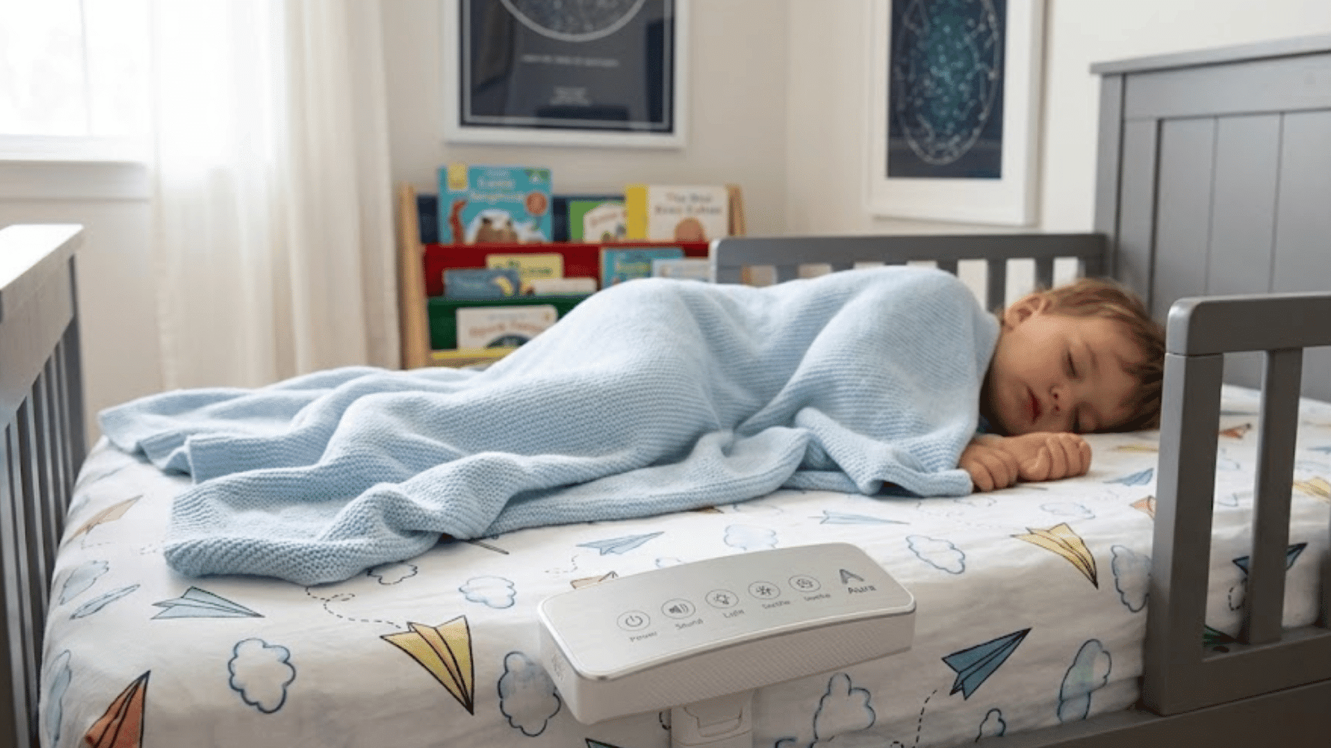 sleeping toddler resting in a safe low bed with blanket during crib to bed transition