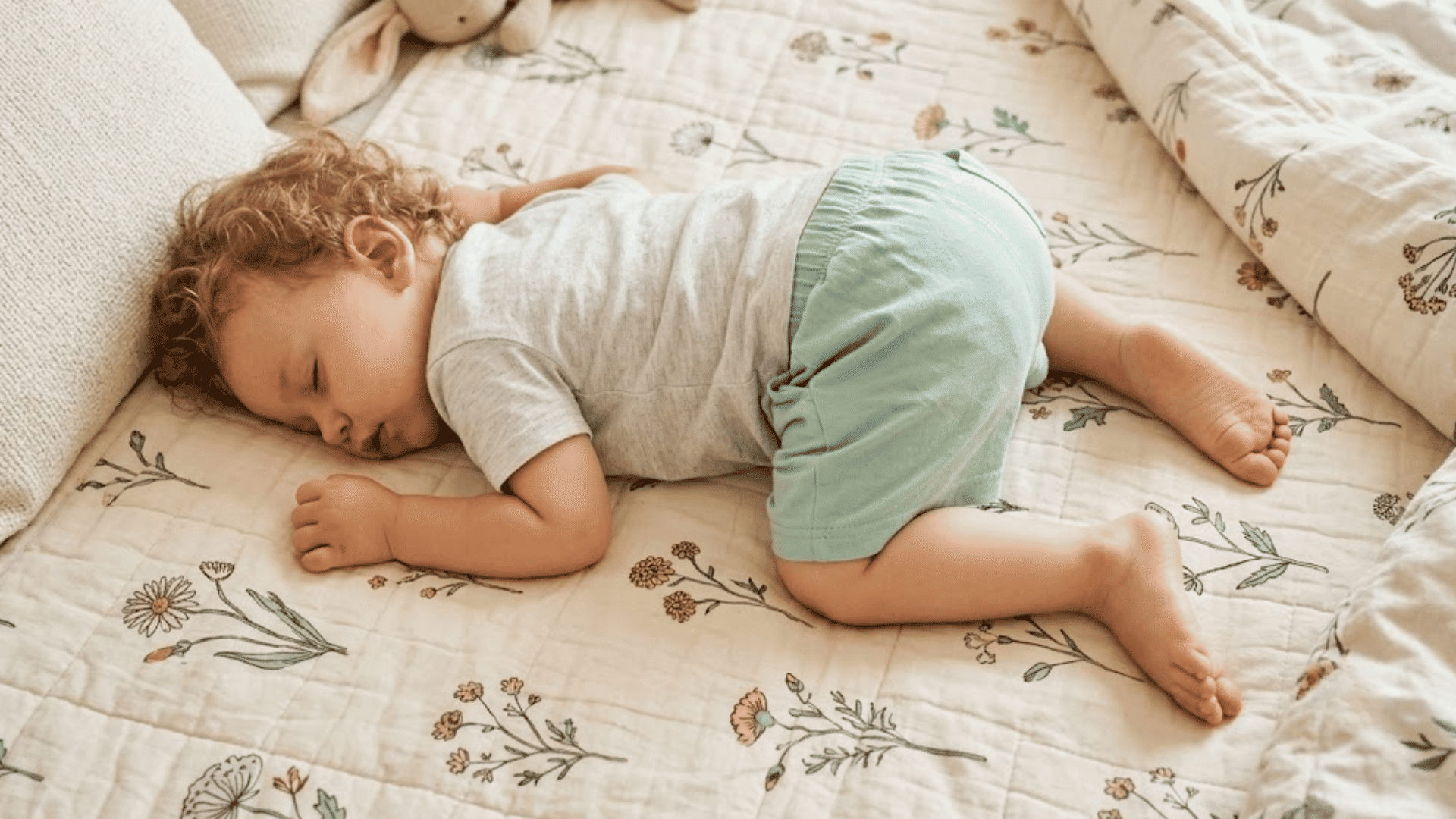 toddler sleeping peacefully on a soft bed during nap time in a cozy bedroom setting