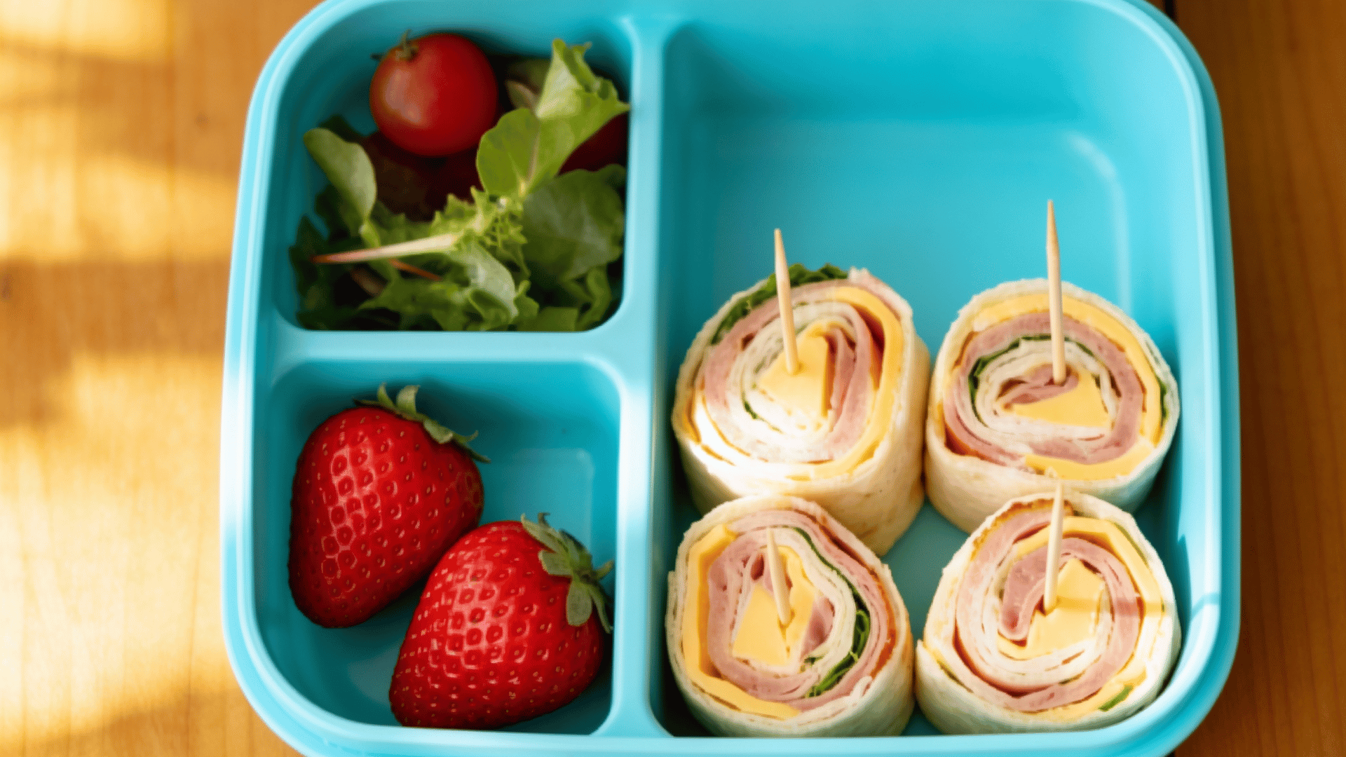 turkey and cheese pinwheel roll-ups packed in a light blue kids lunchbox