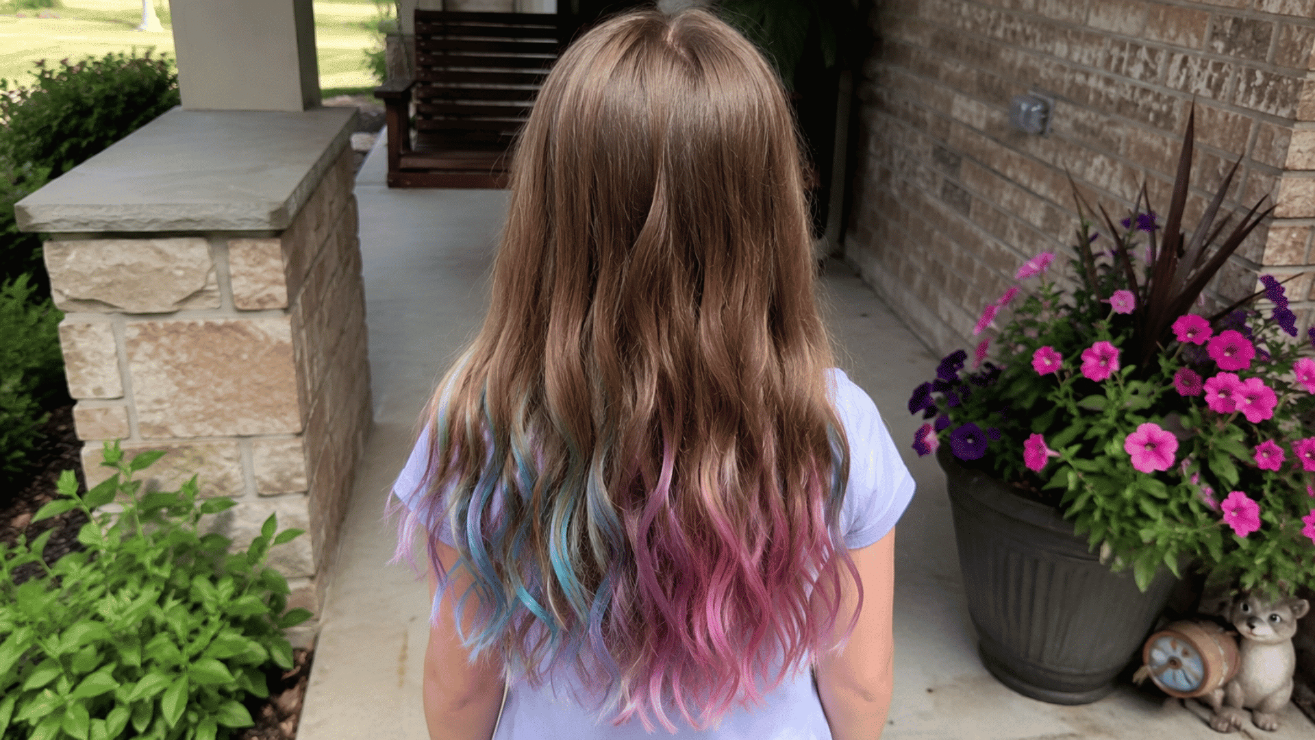 wavy brown hair with soft blue purple and pink chalk tips near flower planter