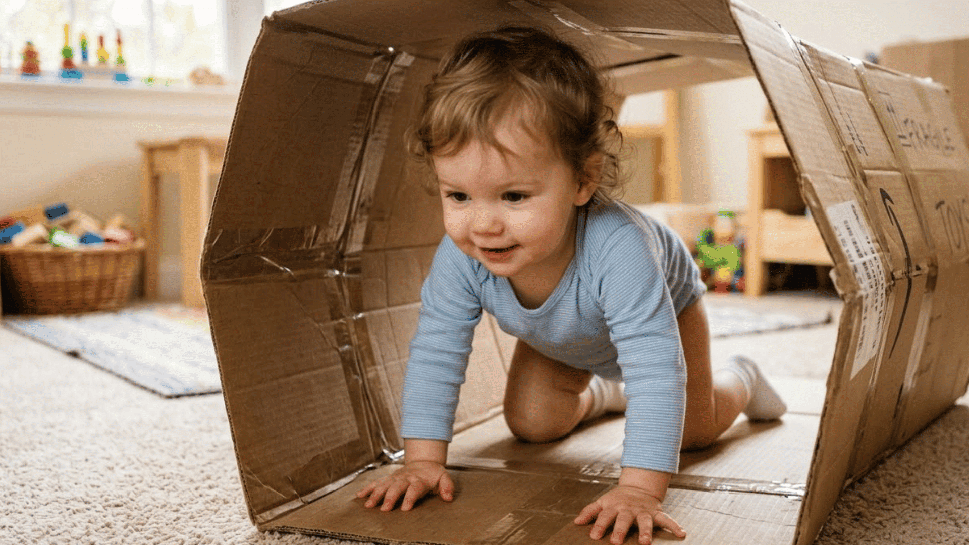 toddler crawls through a tunnel made from taped together cardboard boxes indoors