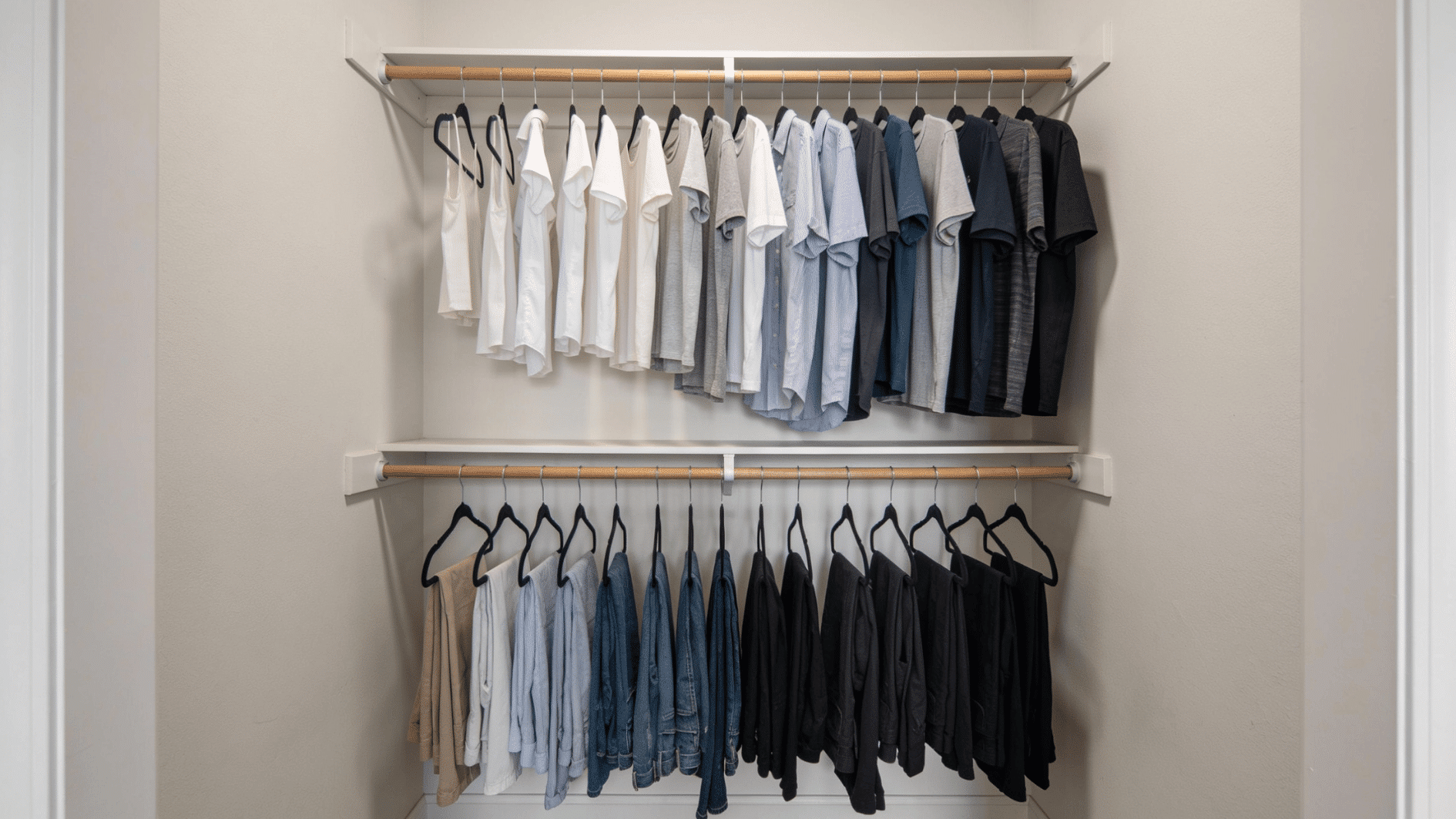 double hanging closet system with two rods holding neatly arranged shirts and pants for extra storage space
