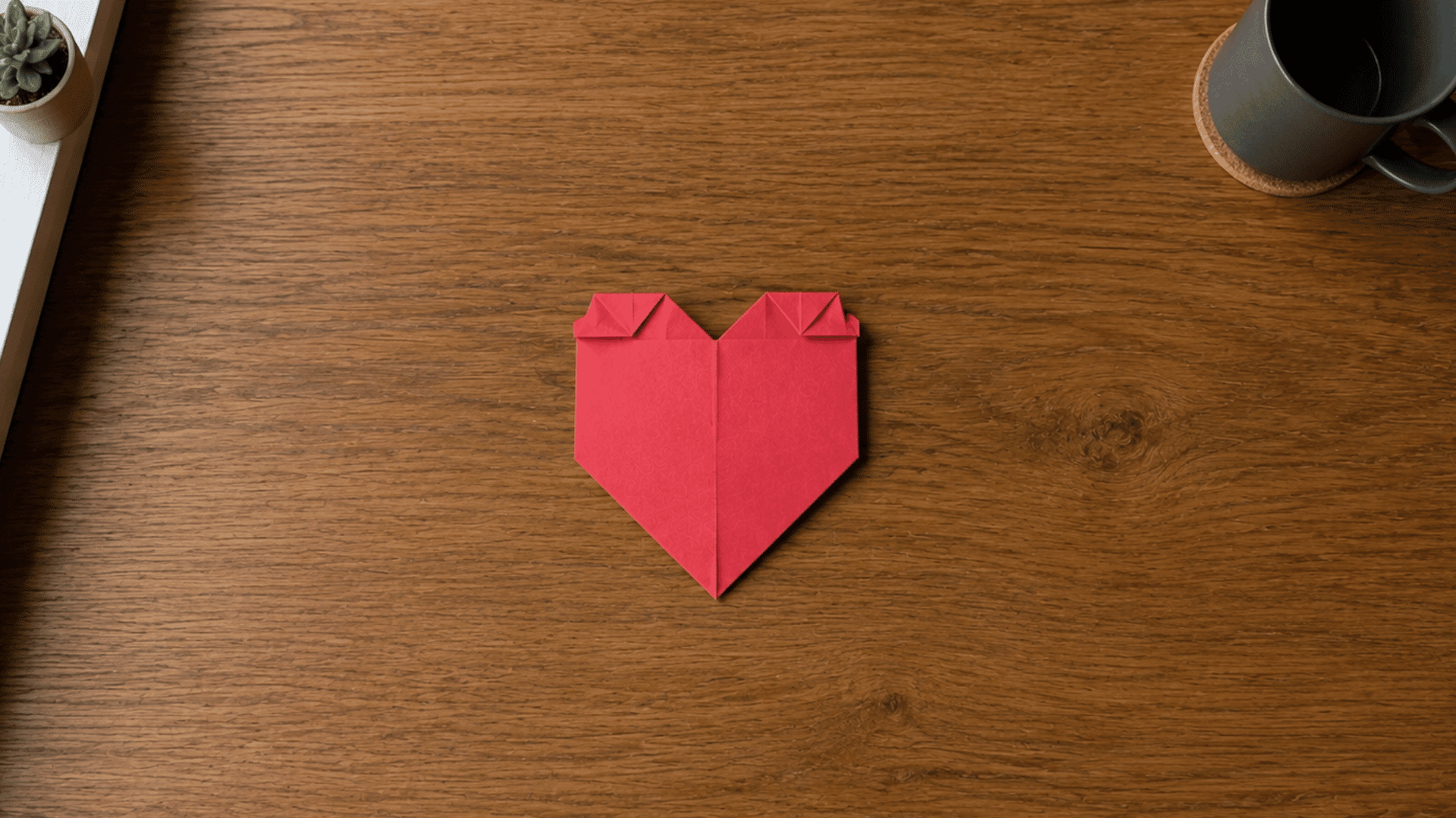 red paper folded into the rounded top shape of an origami heart