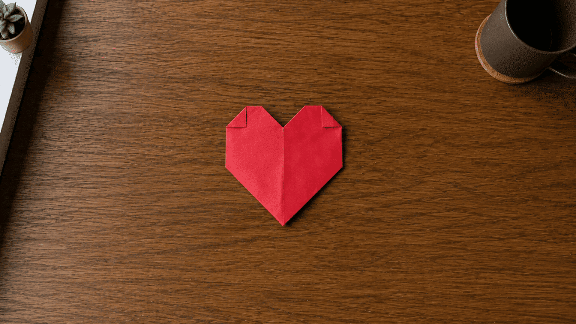 red paper heart with small finishing folds tucked in at the top corners