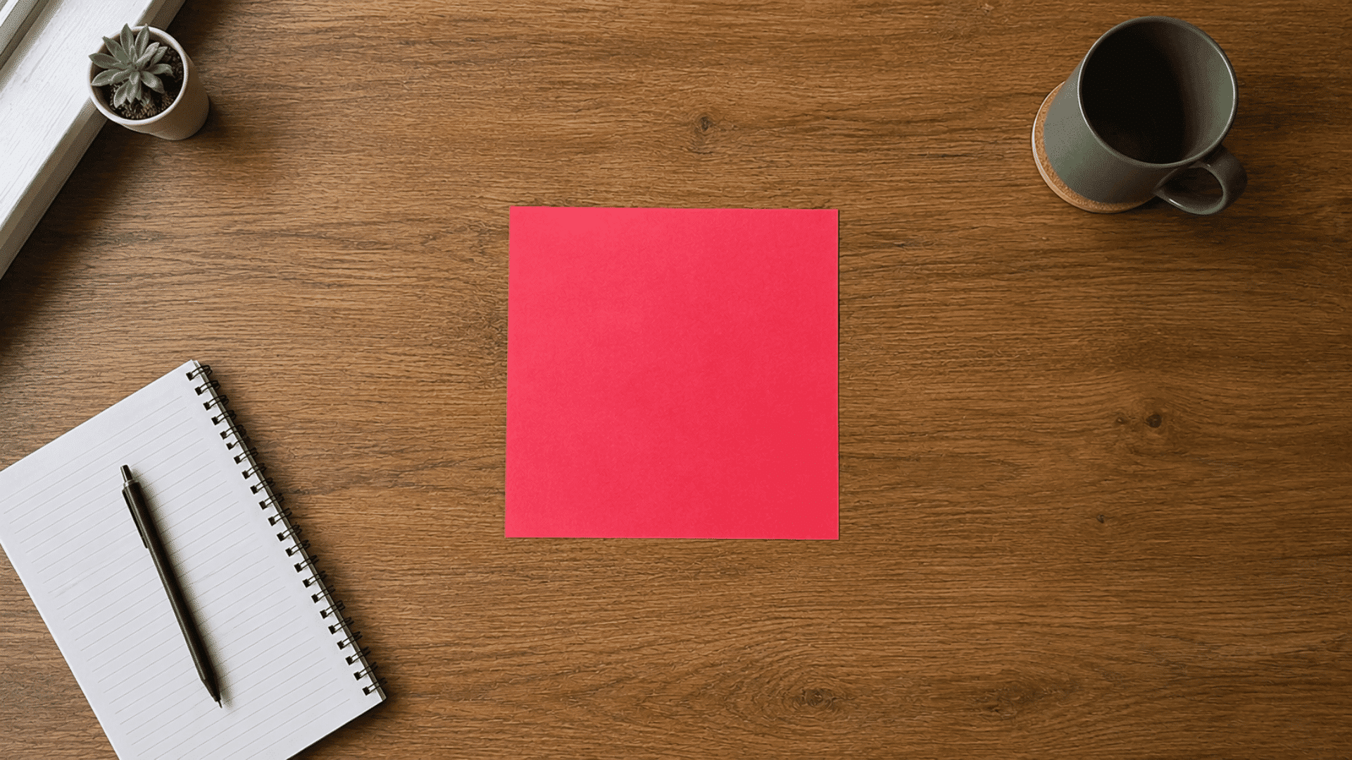 red square paper on a wooden table before folding for an origami heart tutorial