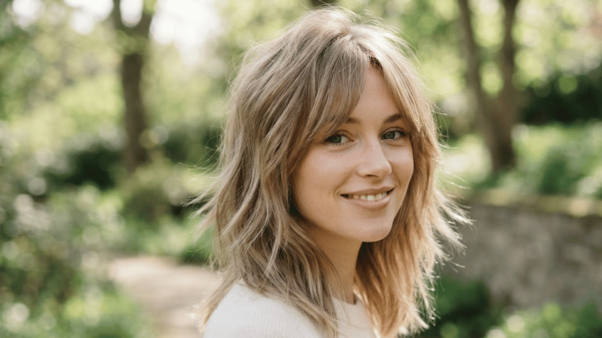 shoulder length haircut with long layers and soft face framing pieces styled outdoors with natural movement hair (1)