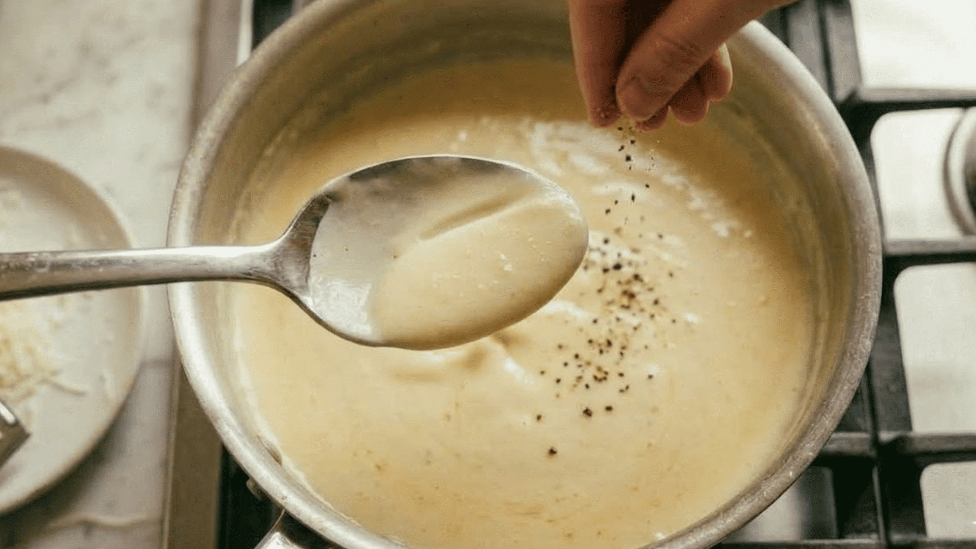 finished alfredo sauce coating the back of a spoon