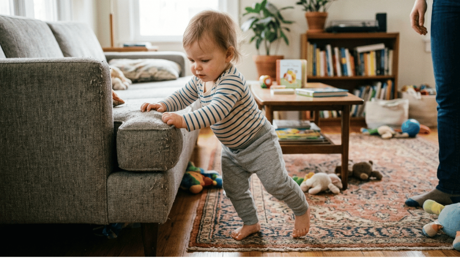 toddler pulling up to stand while holding onto furniture for support