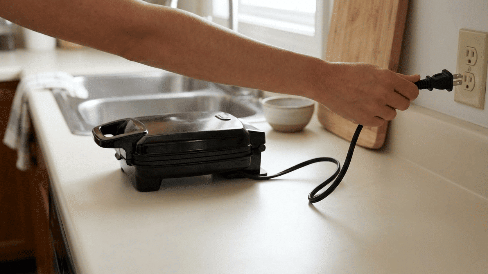 unplugging the waffle maker from the power outlet