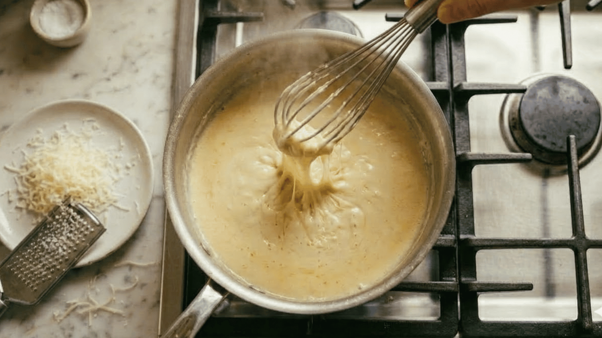 parmesan cheese being whisked into cream until smooth and glossy