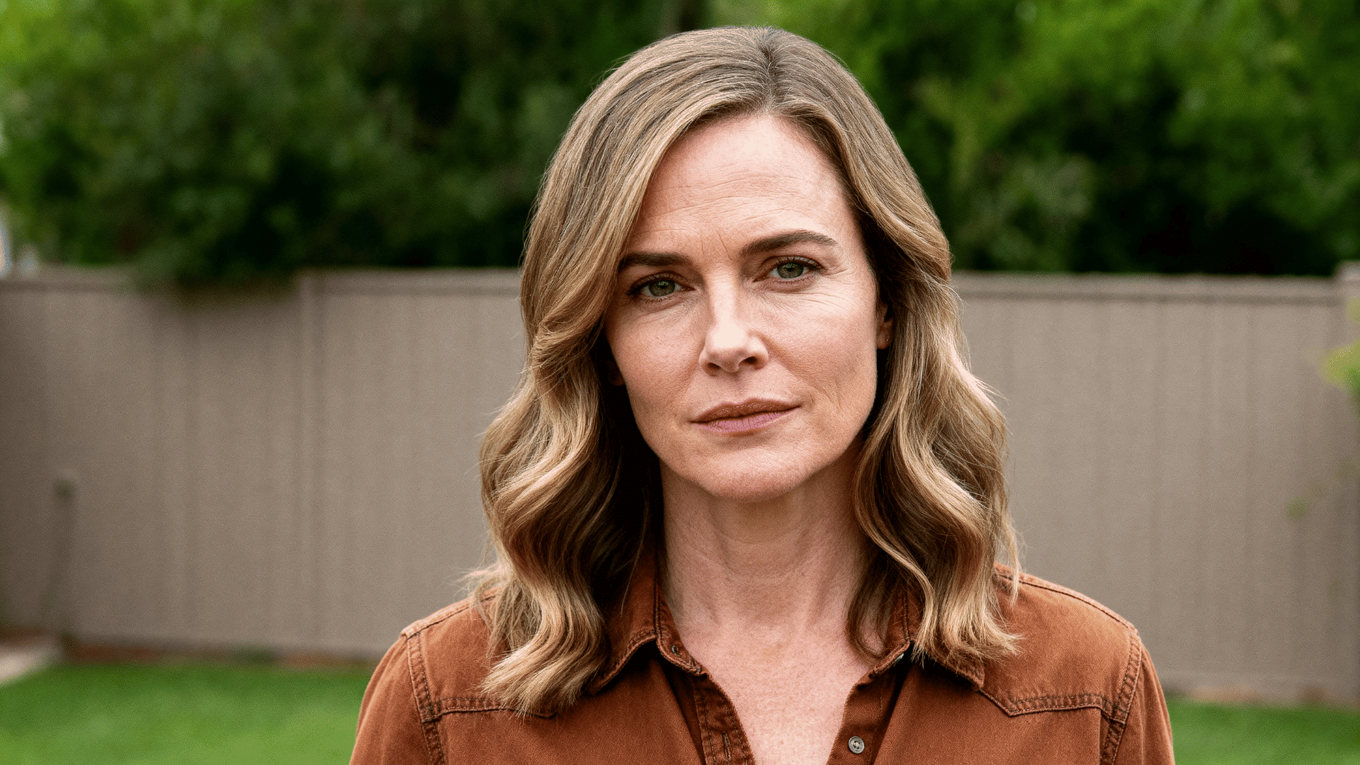 woman with fine wavy dirty blonde hair styled in a soft, medium-length feathered haircut with natural flipped ends