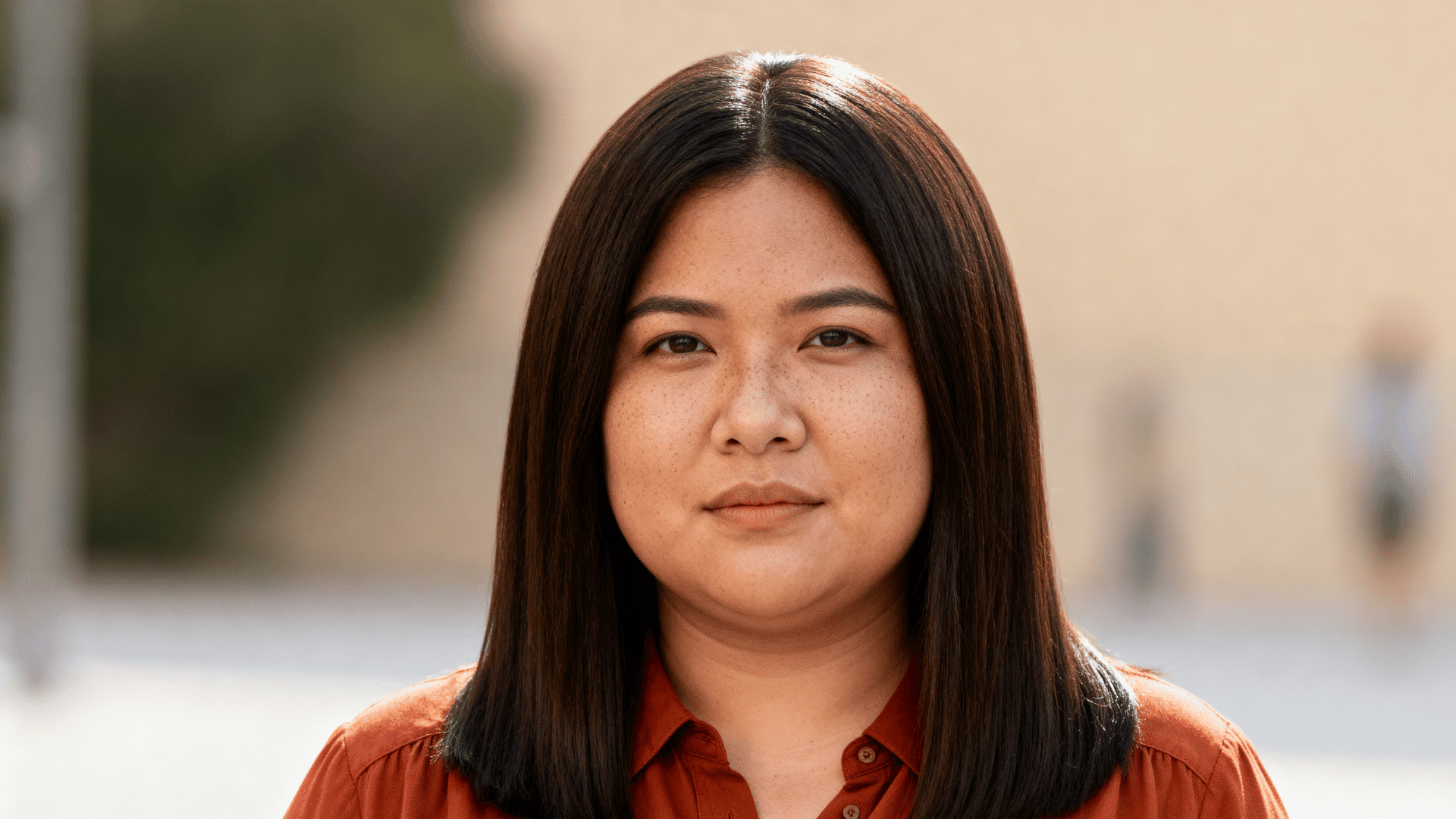 woman with thick straight dark brown hair featuring long face-framing pieces in a smooth medium-length haircut